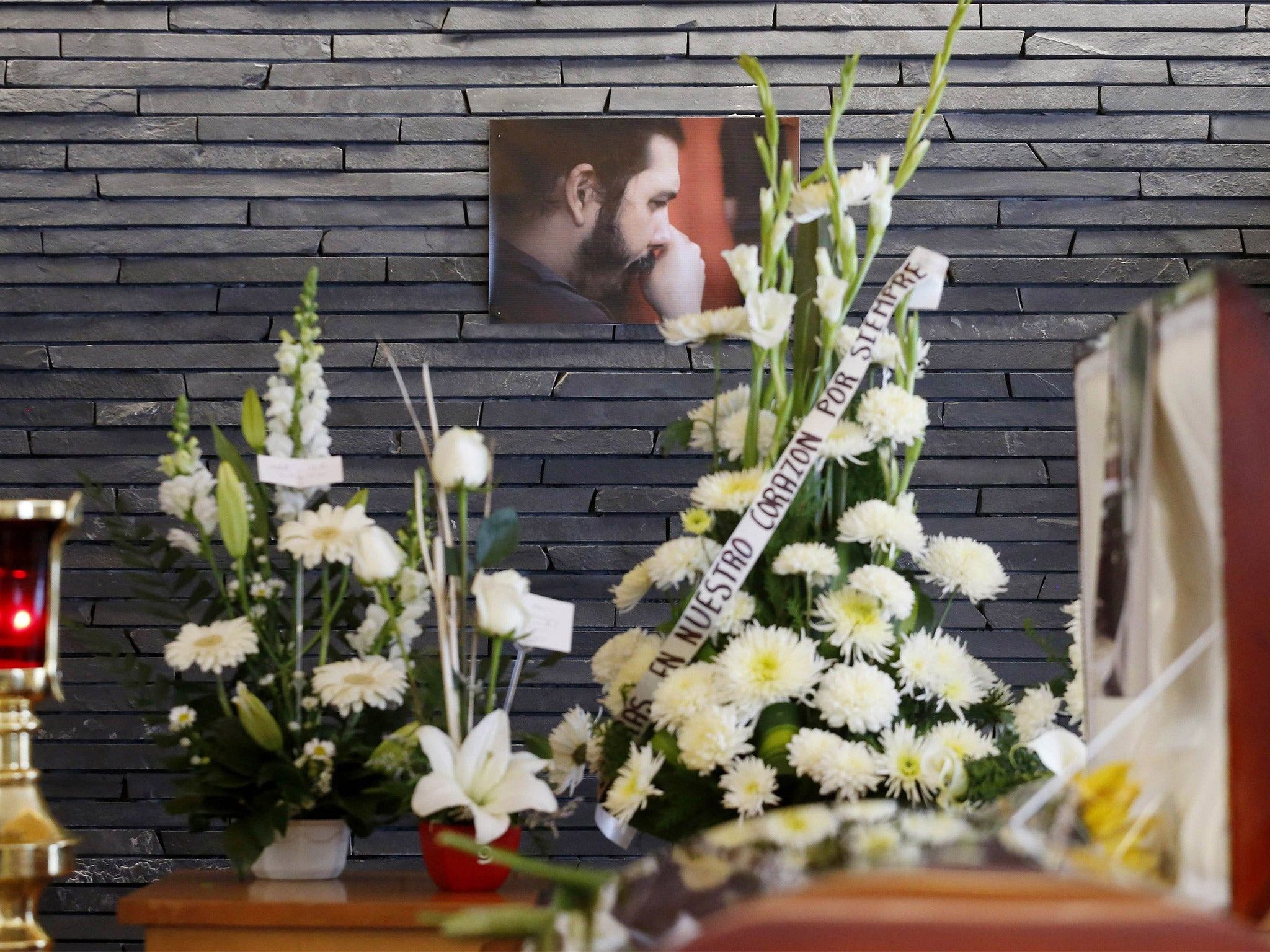 A photo of Canek Sanchez Guevara, the grandson of Cuban revolutionary leader Che Guevara, hangs above his casket during his funeral in Mexico City