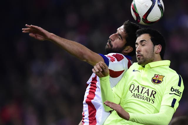 Sergio Busquets challenges for the ball