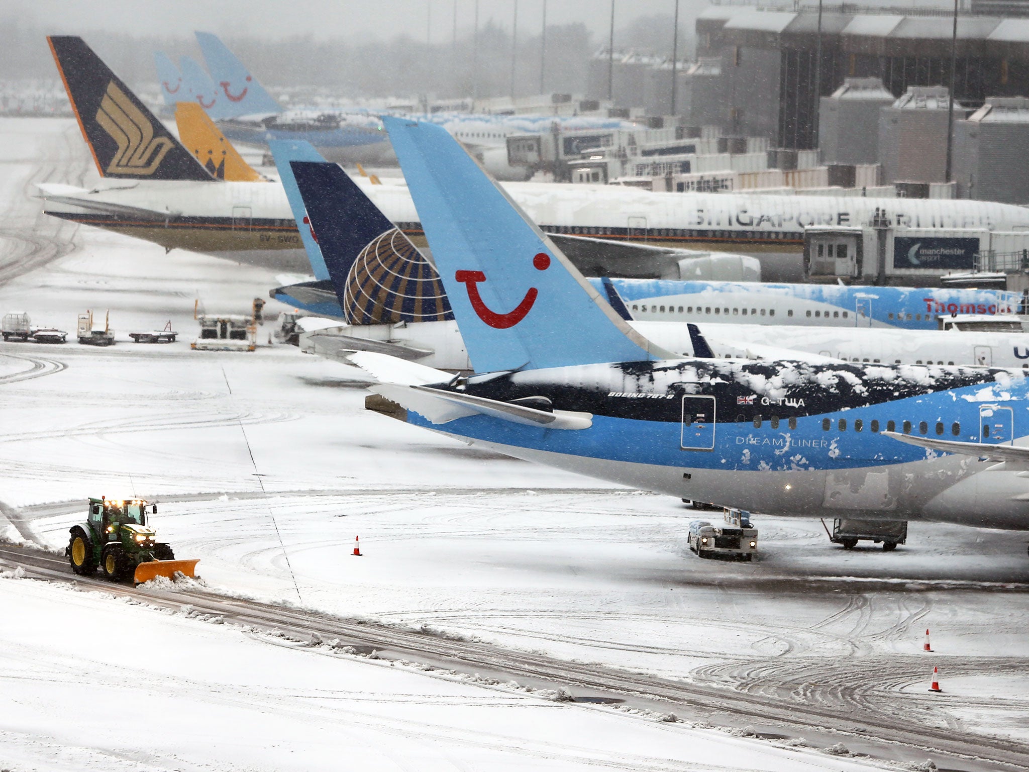 Tractors clear the snow from the runways at Manchester Airport's Terminal 1