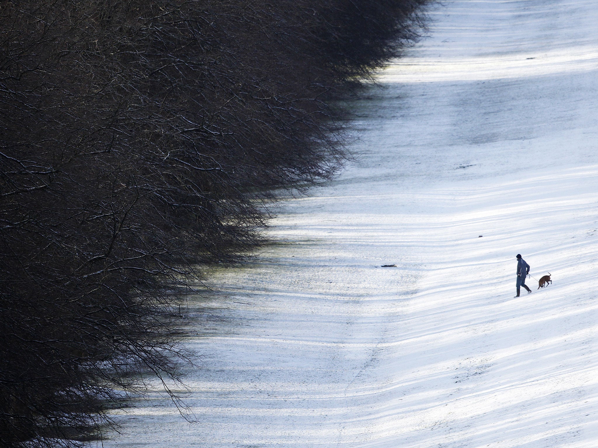 A walker makes his way through the snow in the grounds of Stormont, Belfast, Northern Ireland