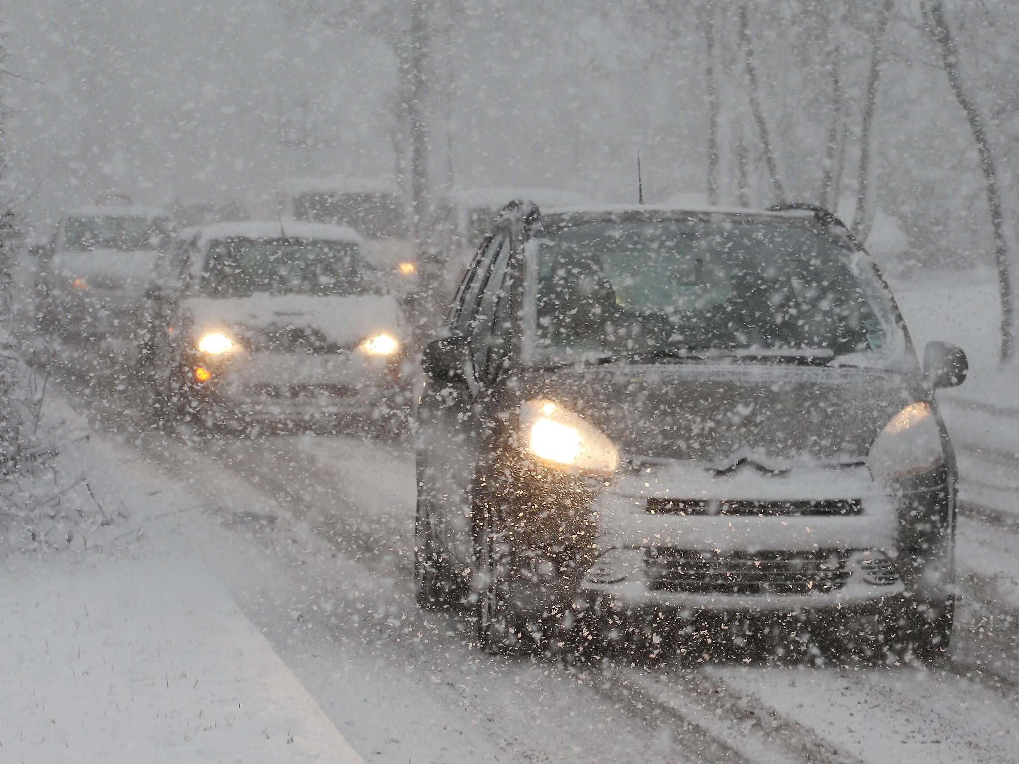 Cars struggle through the snow in West Ewell, England.