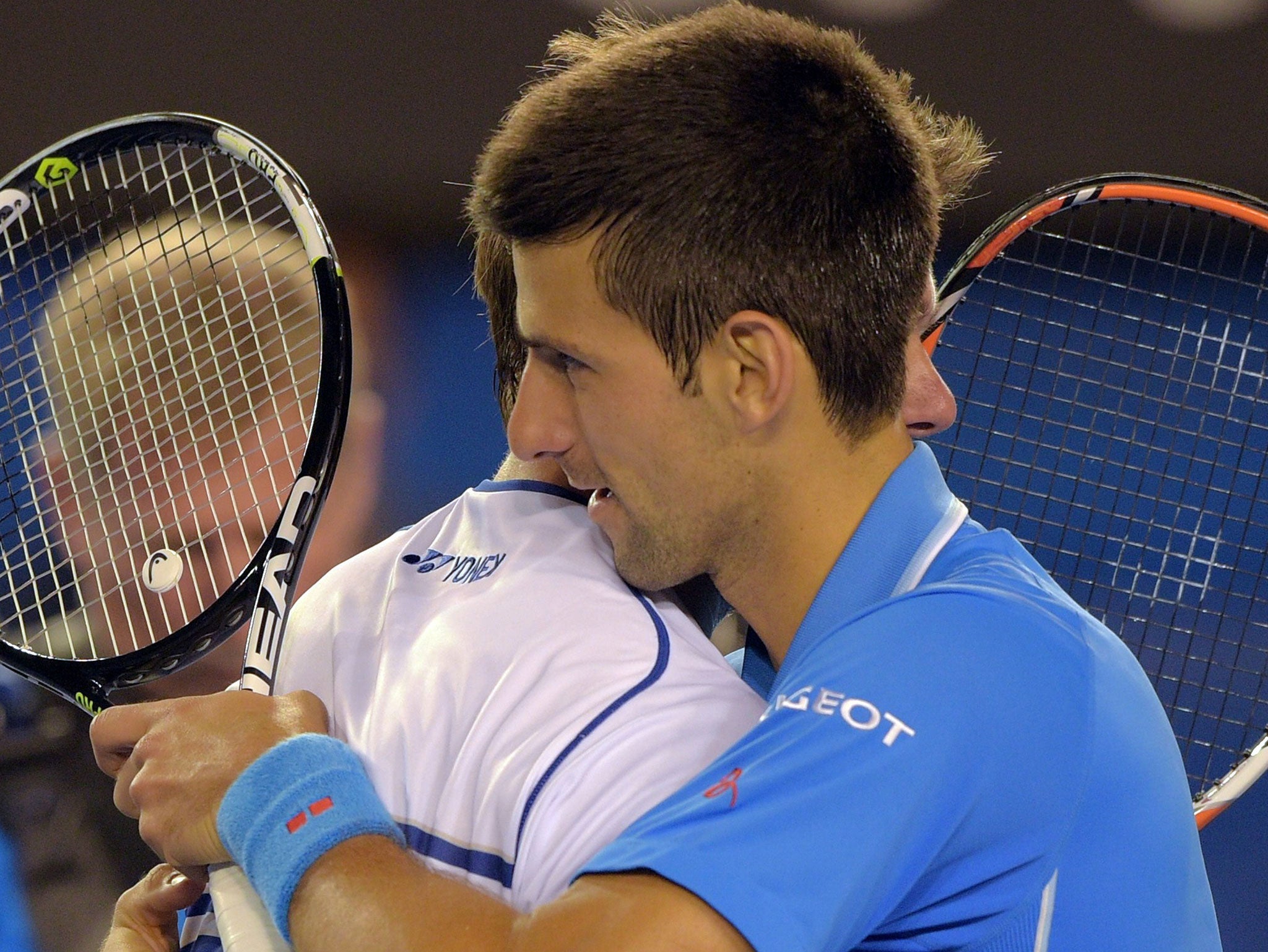 Novak Djokovic consoles Stan Wawrinka after the match