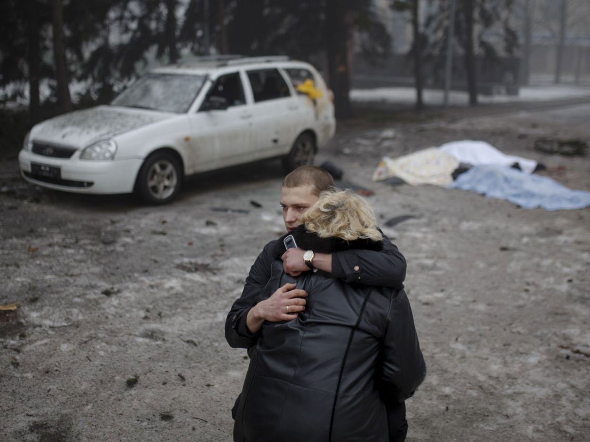 A rebel comforts a wife of a killed civilian in shelling in Donetsk, eastern Ukraine, on 30 January