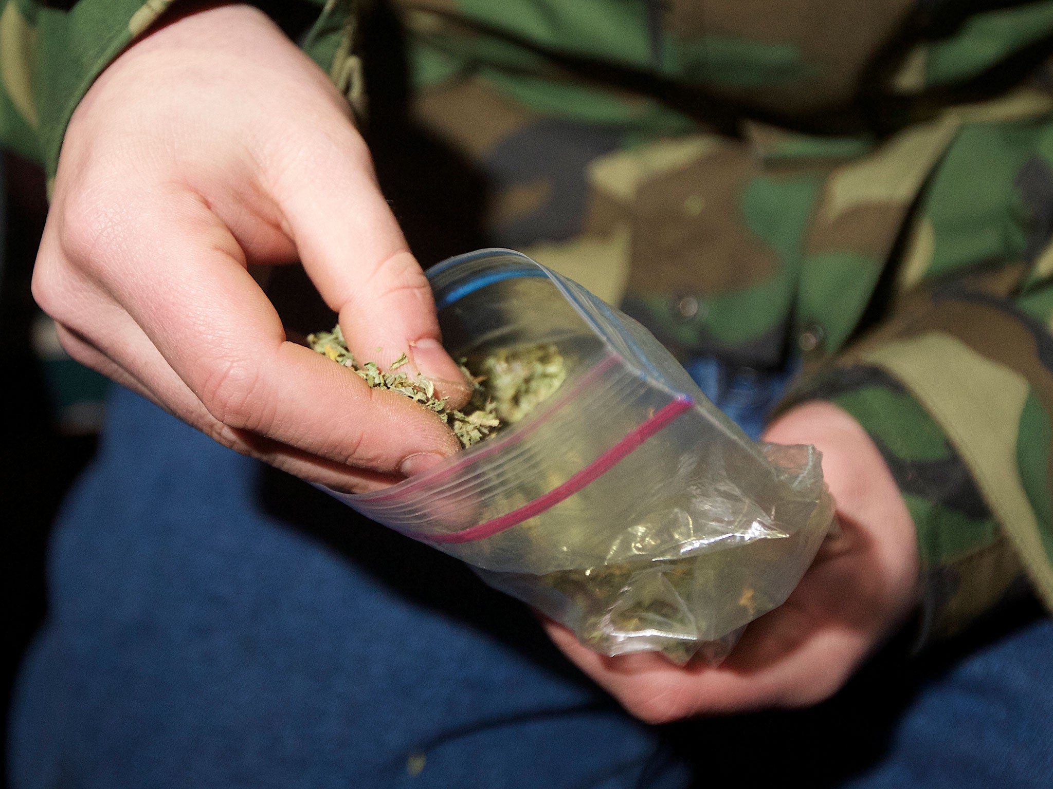 A Seattle resident takes marijuana from a plastic bag