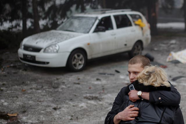 A rebel comforts a wife of a killed civilian in shelling in Donetsk