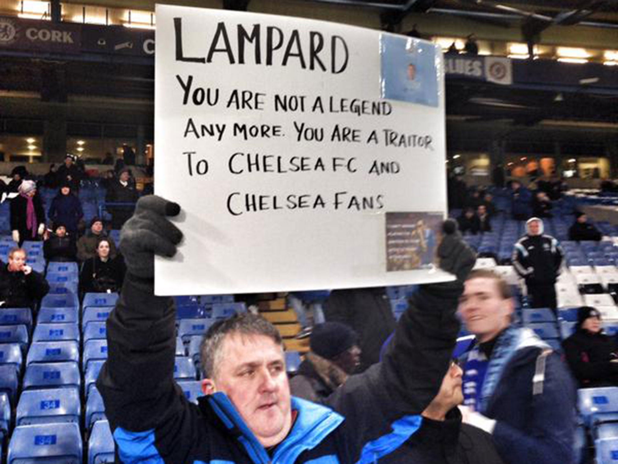 A Chelsea fans holds a sign aimed at Frank Lampard before the game against Manchester City