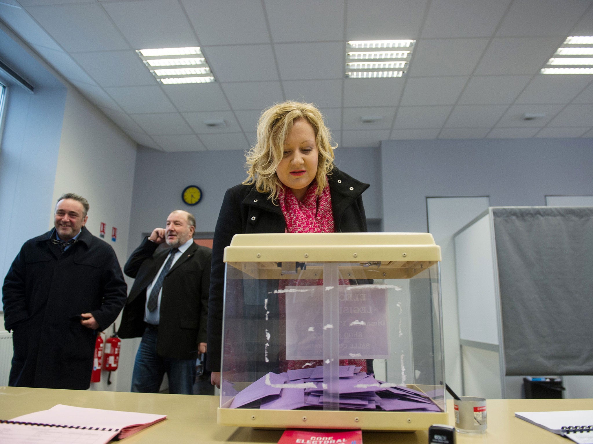 Sophie Montel, French far-right National Front candidate, looks at a ballot box as she arrives at a polling station for the first round of a by-election in the 4th constituency of the Doubs