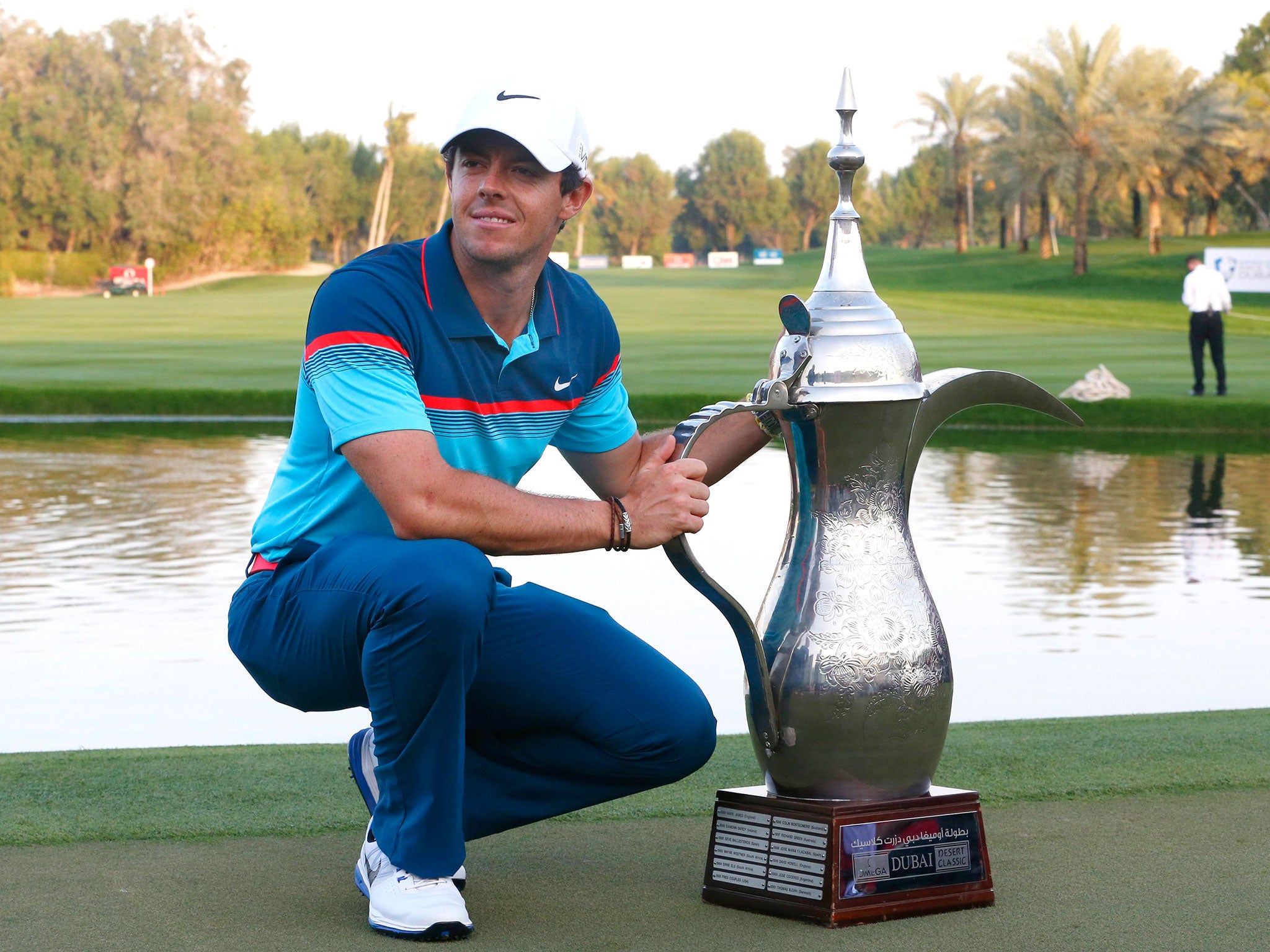 Rory McIlroy poses with the Dubai Desert Classic trophy after his victory