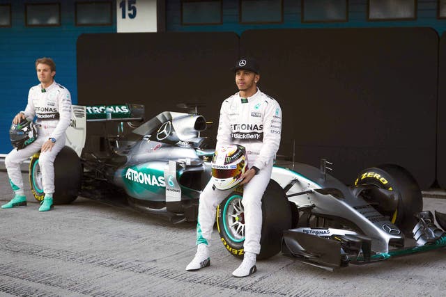 Lewis Hamilton, right, and Nico Rosberg pose with the new Mercedes W06 car in Spain 
