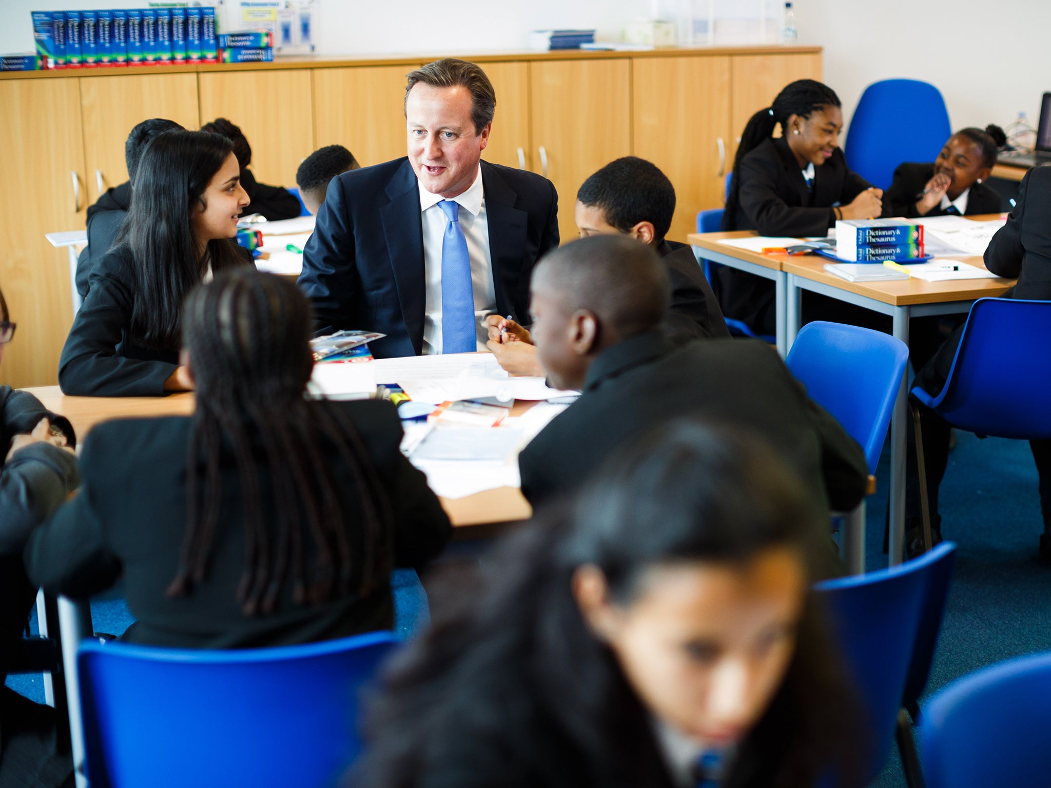 The Prime Minister attending a class at Perry Beeches III Free School in Birmingham in 2013; he has admitted that state funding per pupil will fall in real terms over the next five years under the Conservatives (Getty)