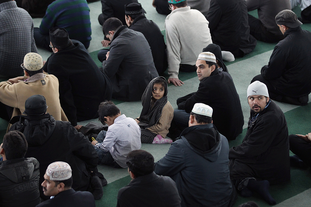 A young Muslim girl waits to pray with Muslim men at Baitul Futuh Mosque in Morden
