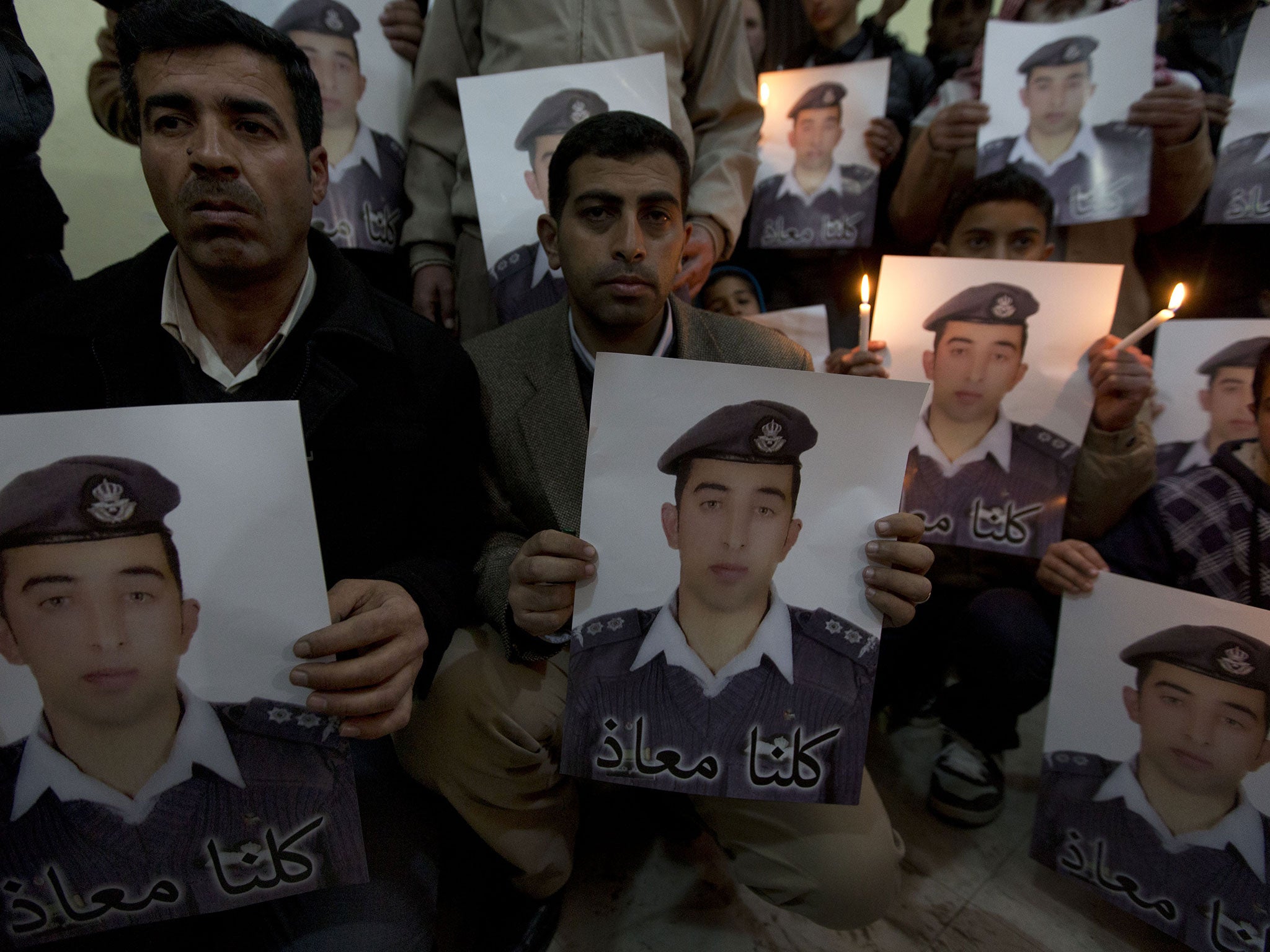 Jawdat Al-Kaseasbeh, brother of Jordanian pilot, Lt Muath al-Kaseasbeh, carries a poster and message that reads "we are all Muath"