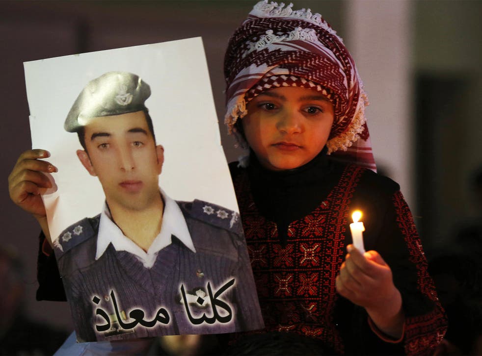 A Jordanian girl holds a poster of pilot Muath al-Kasaesbeh during a candlelit vigil in Amman on Monday