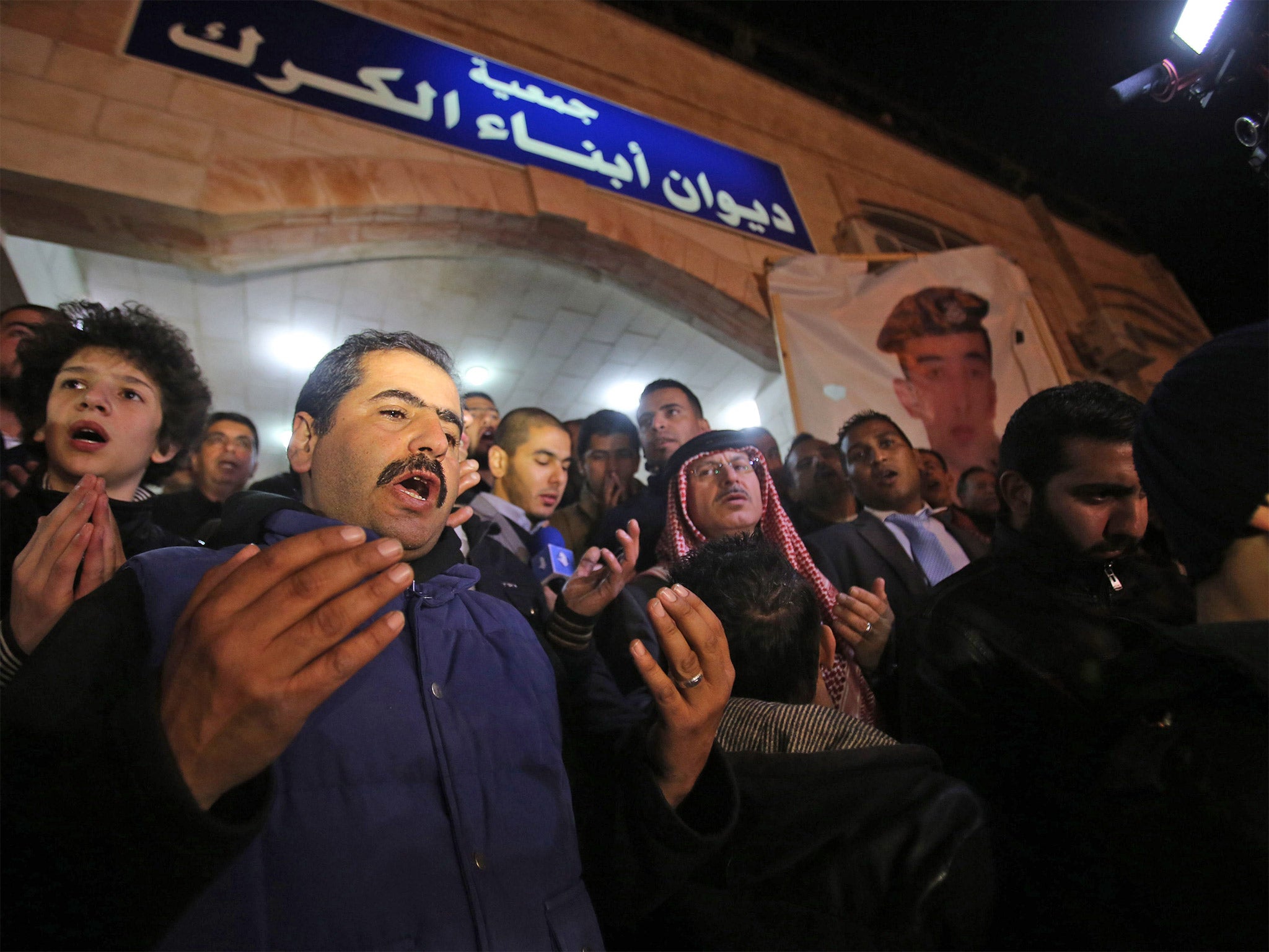 Supporters and relatives of pilot Muath al-Kaseasbeh say prayers following his reported killing, in the Jordanian capital Amman (Getty)