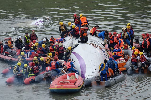 Rescue personnel work to free passengers from a TransAsia ATR 72-600 turboprop plane that crash-landed into a river outside Taiwan's capital Taipei 