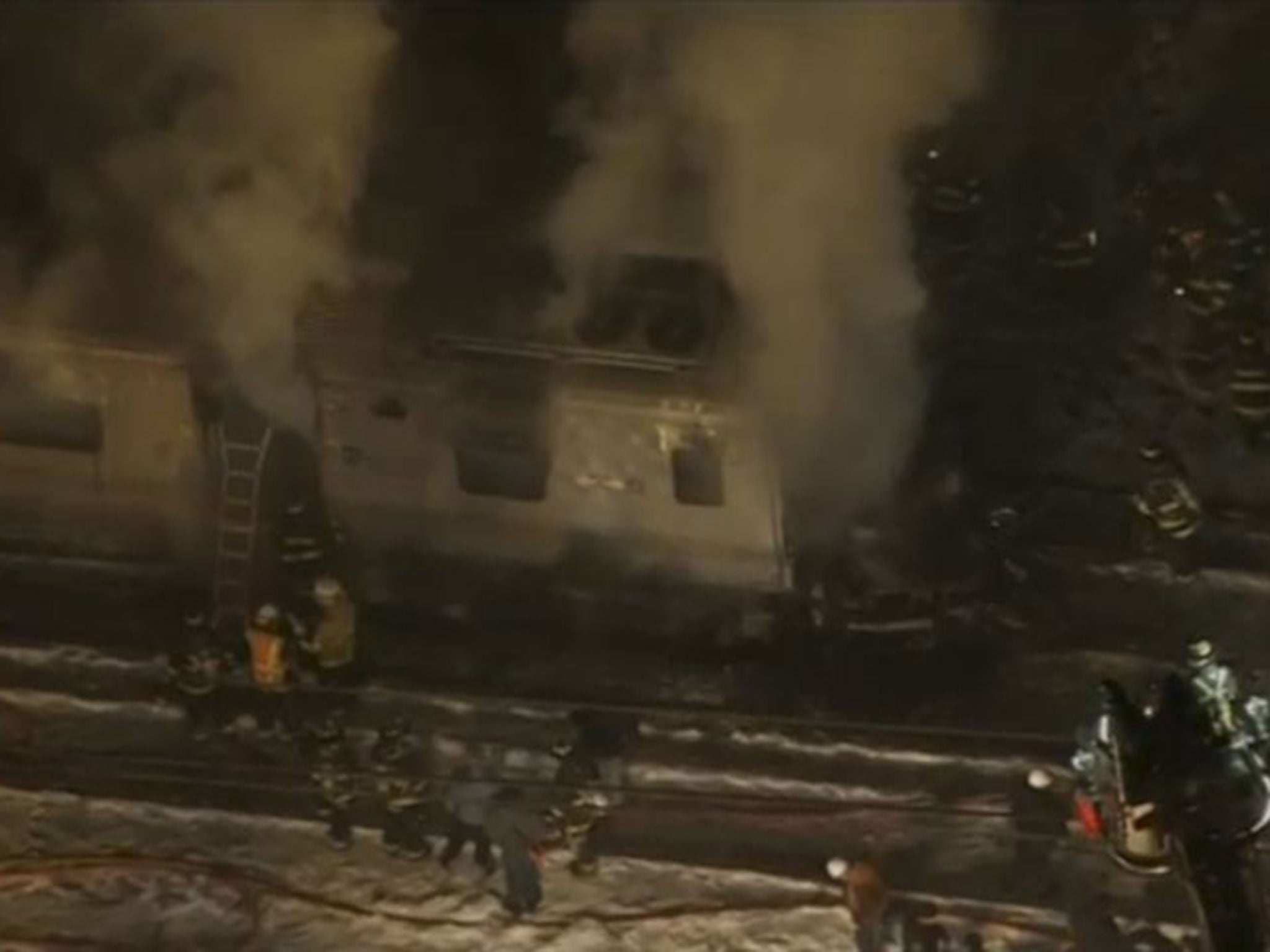 A still image captured from WNBC-TV aerial video shows first responders battling a fire on a New York City Metro-North train following an accident near Valhalla, New York