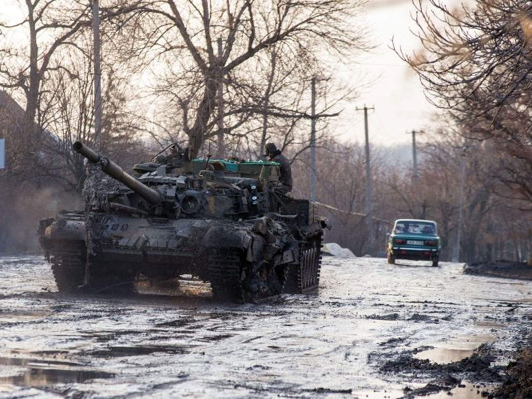 An armoured vehicle pulls a Ukrainian tank in the village of Horlivka, Donetsk region, on February 4, 2015, after it was damaged during combat between the Ukrainian forces and pro-Russian separatists.