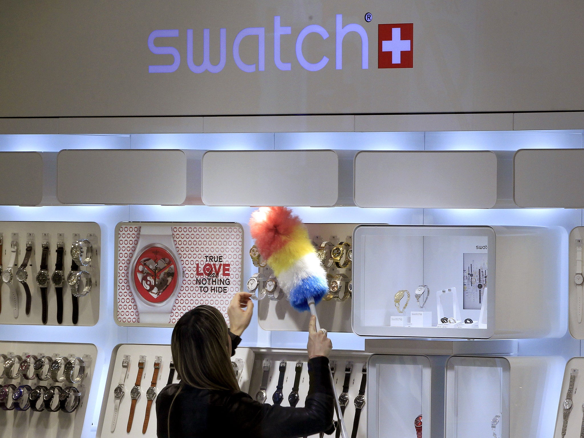 Swatch dusting off its smart watches: a woman cleans a display of watches at a Swatch store