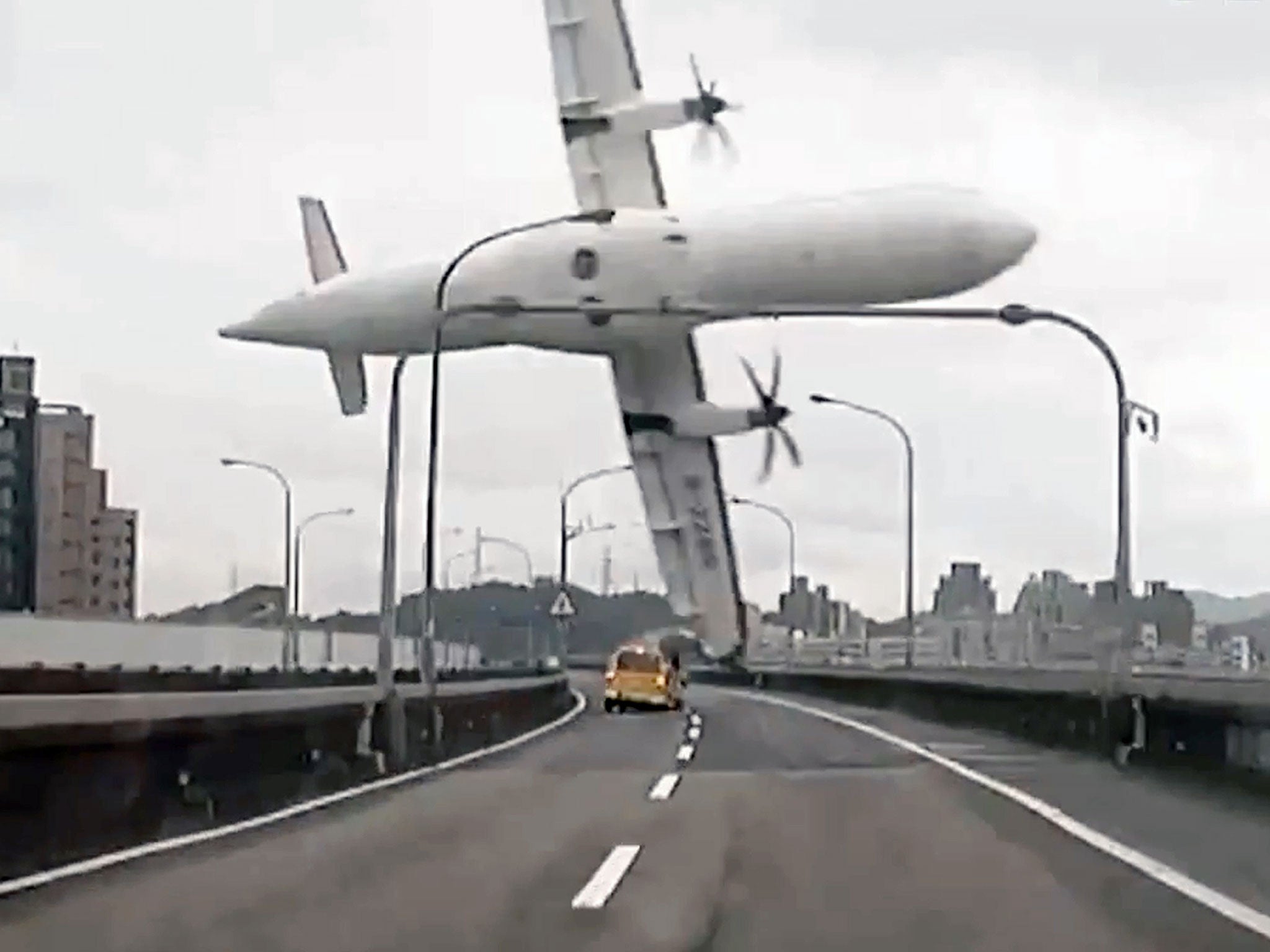 A TransAsia ATR 72-600 turboprop plane clipping an elevated motorway and hitting a taxi before crashing into the Keelung river outside Taiwan's capital Taipei in New Taipei City