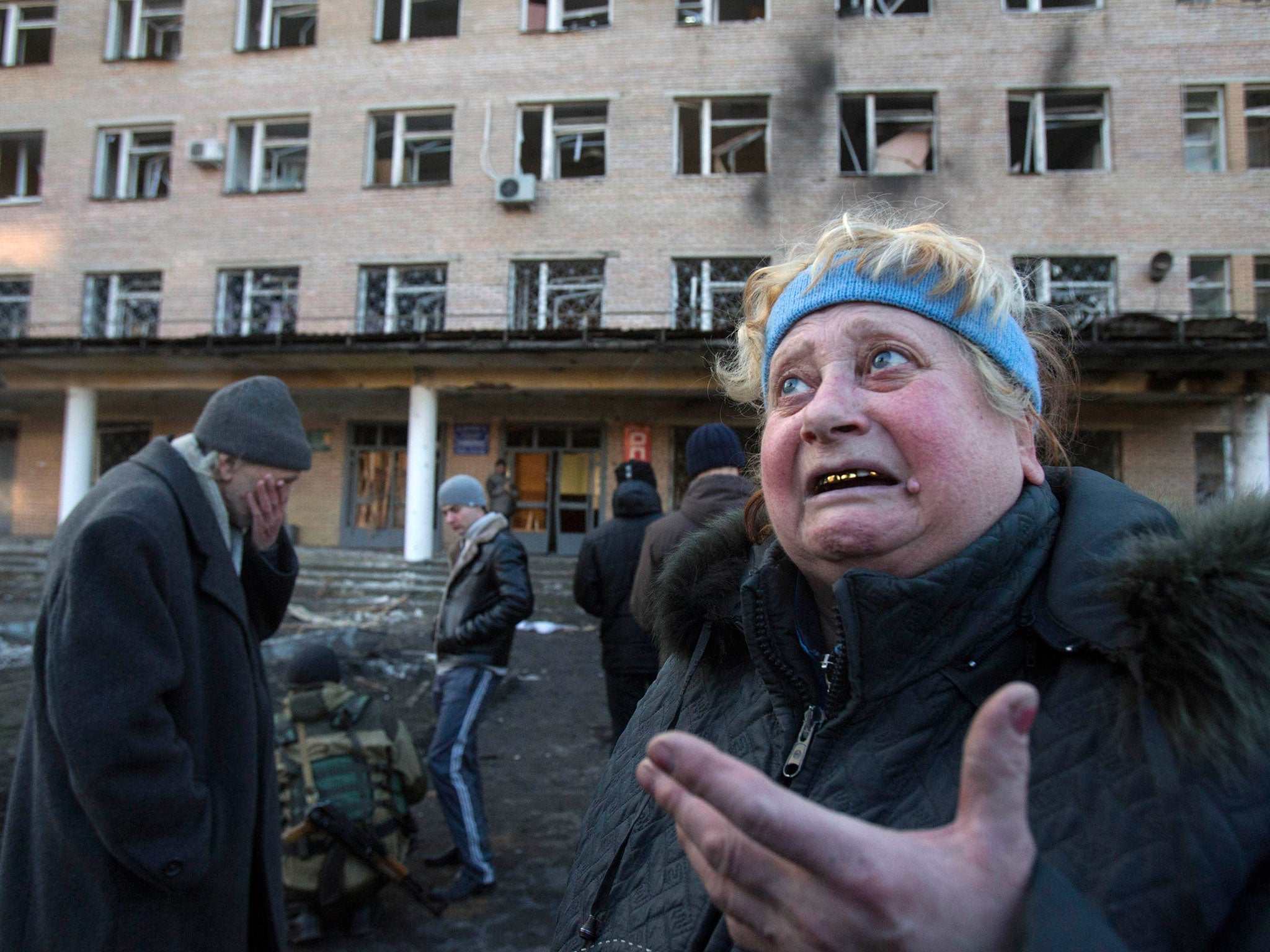 A woman reacts outside a damaged hospital in Donetsk, Ukraine