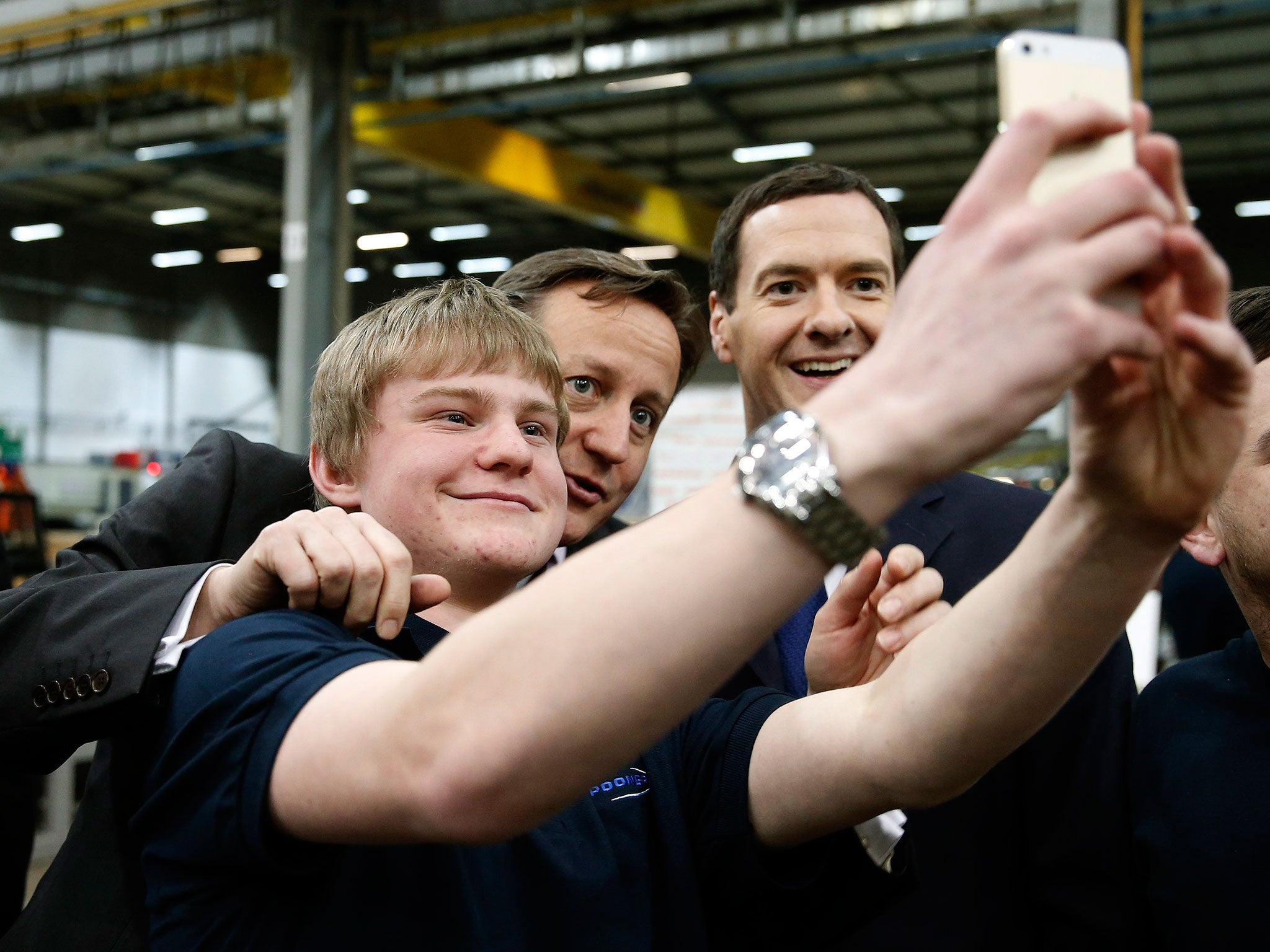 Prime Minister David Cameron and Chancellor of the Exchequer George Osborne pose for a selfie photograph with an apprentice during a visit to the Spooner engineering works in Ilkley