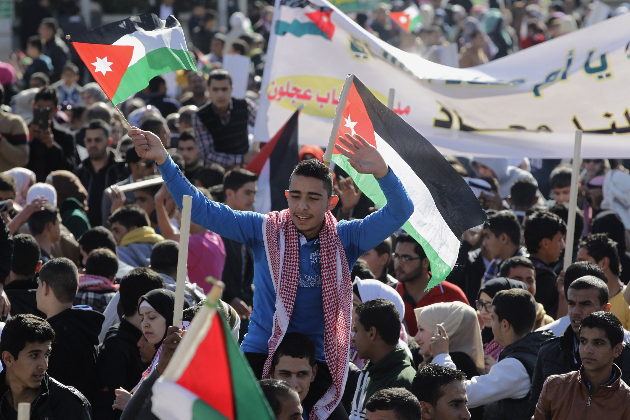 Jordanians chant slogans to show their support for the government against terror during a rally in Amman, Jordan