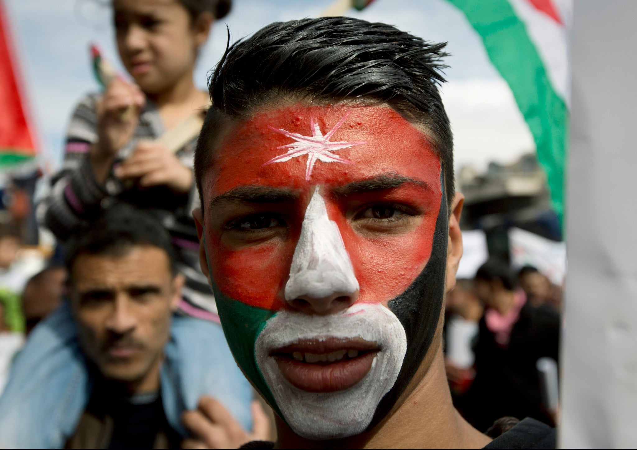 A Jordanian demonstrator paints his face with his national flag while taking part in an anti-IS group rally in Amman, Jordan