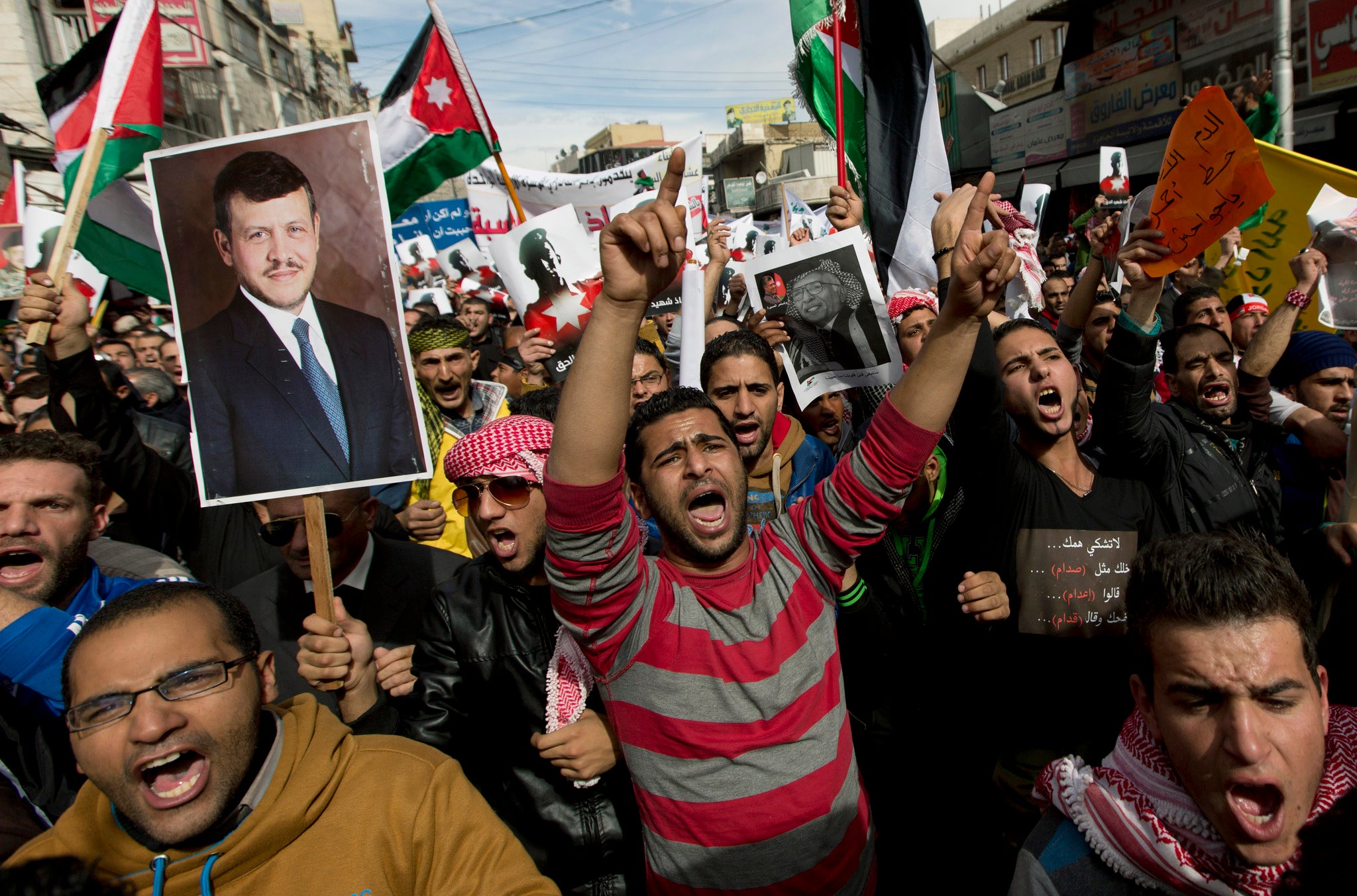 Demonstrators chant anti-Islamic State group slogans and carry posters with pictures of Jordanian King Abdullah II, late King Hussein and slain Jordanian pilot, Lt. Muath al-Kaseasbeh, during an anti-IS group rally in Amman, Jordan