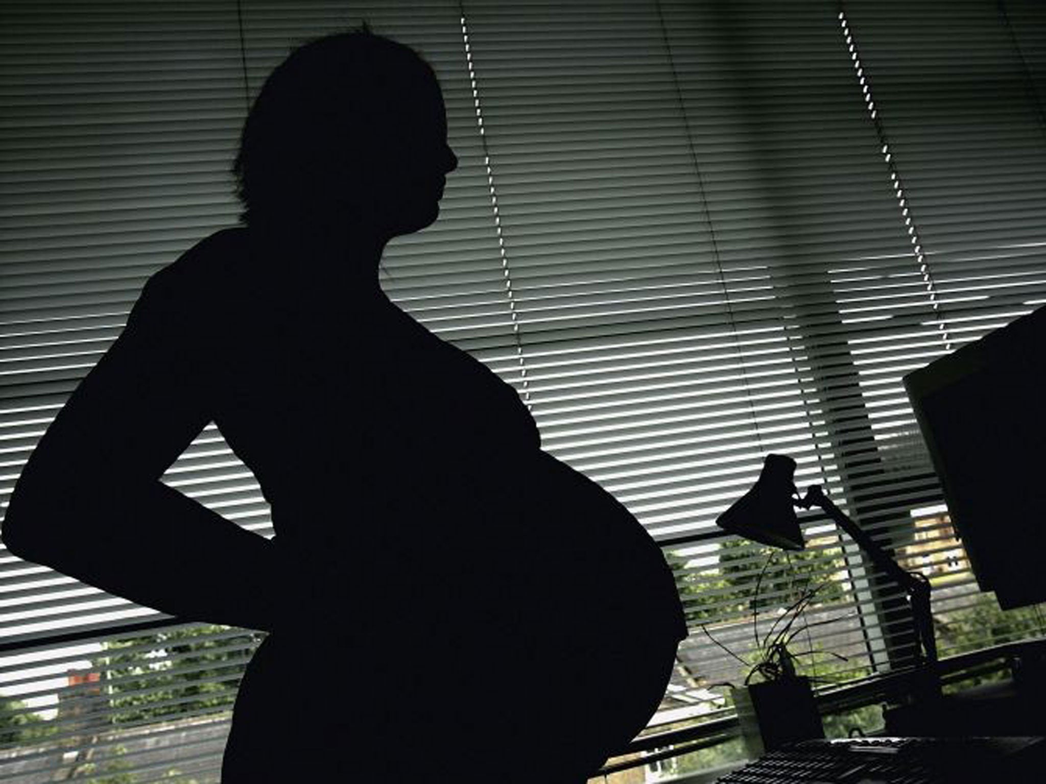 Premium Photo  A pregnant woman stands against a white wall and