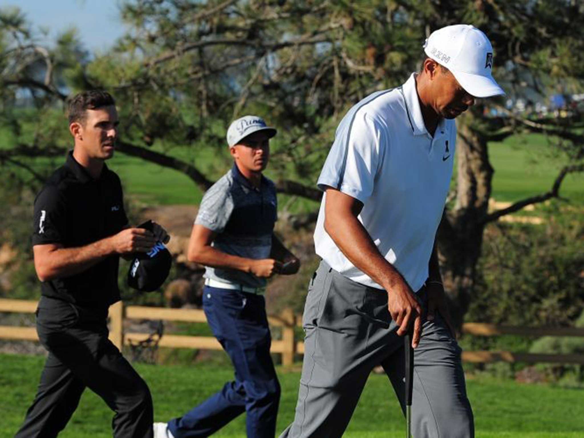 A grimacing Tiger Woods walks off the Torrey Pines course in San Diego, retiring after completing just 11 holes