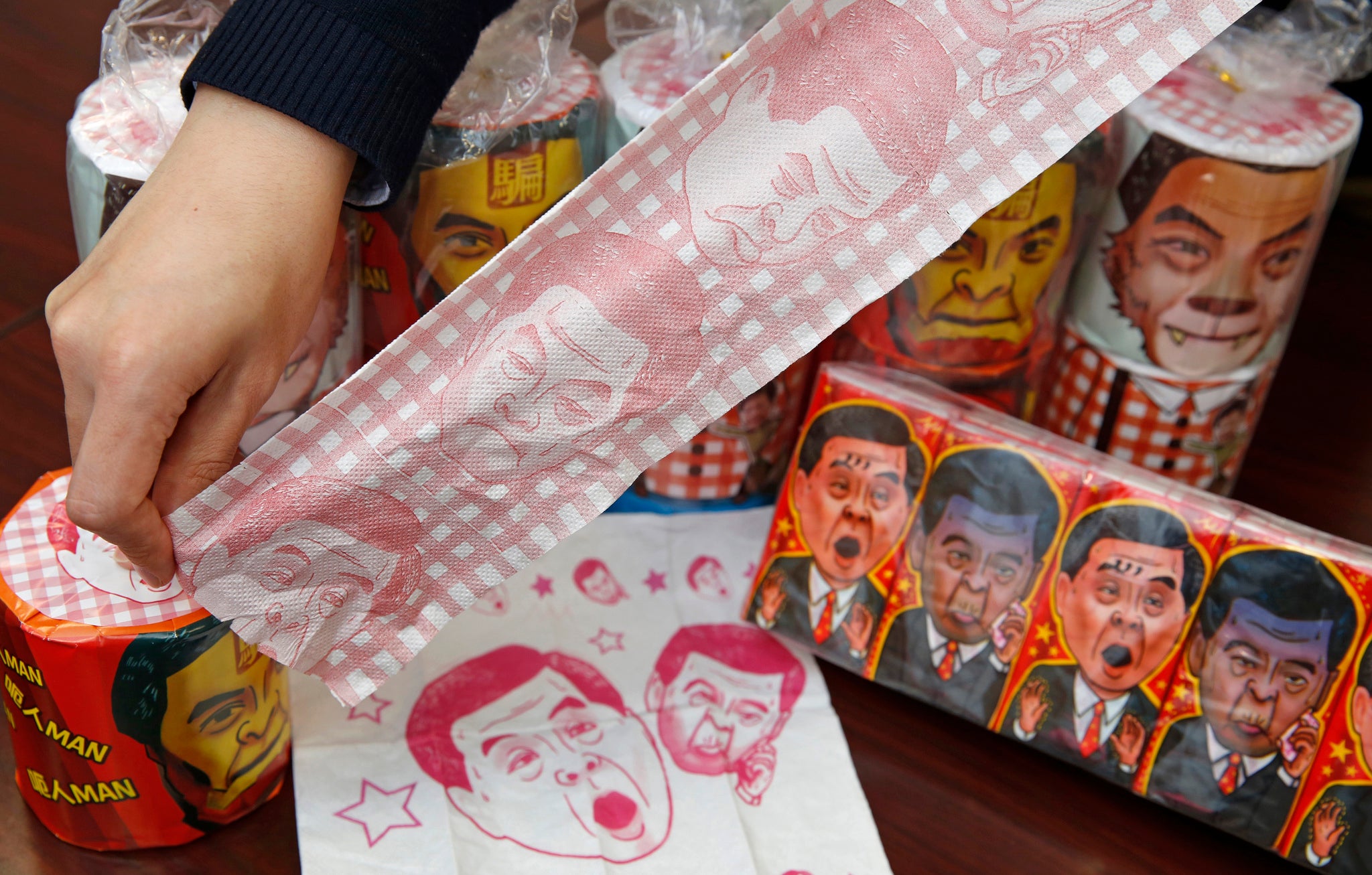 Hong Kong Democratic Party Vice Chairman Lo Kin-hei shows off rolls of toilet paper and packages of tissue paper printed with images of pro-Beijing Hong Kong Chief Executive Leung Chun-ying at his office in Hong Kong Saturday, Feb. 7, 2015. Lo said Saturd