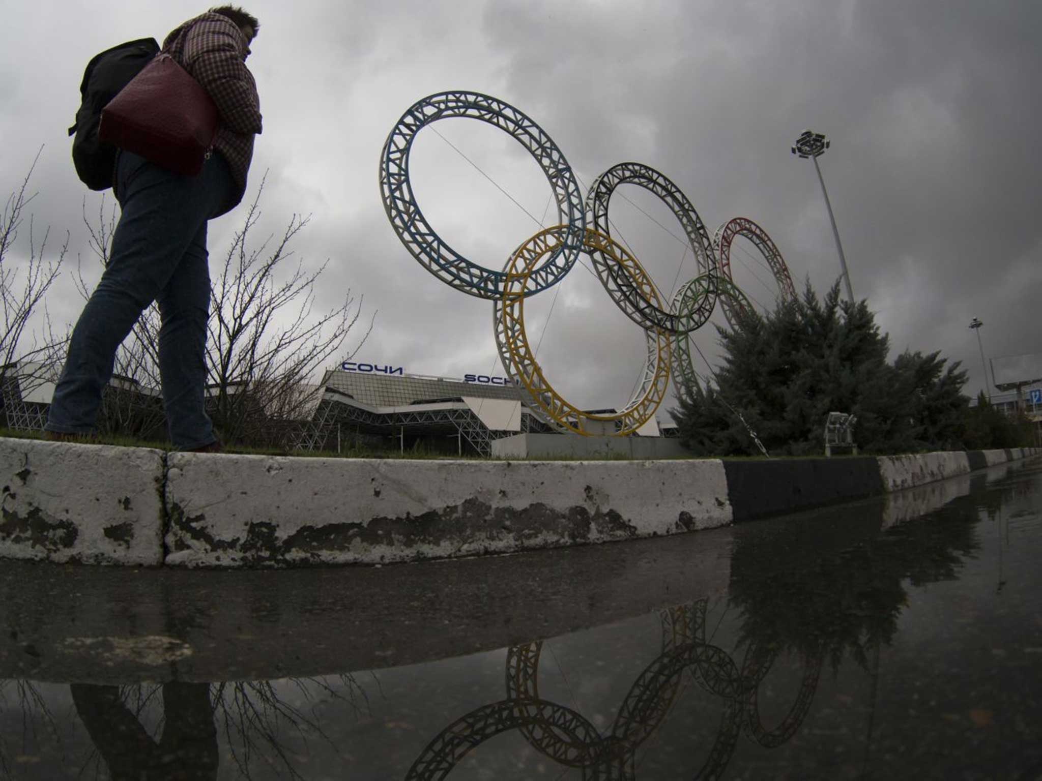 A woman walks past the seemingly abandoned Sochi grounds
