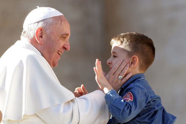 Smacking with dignity: Pope Francis greets a child last year
