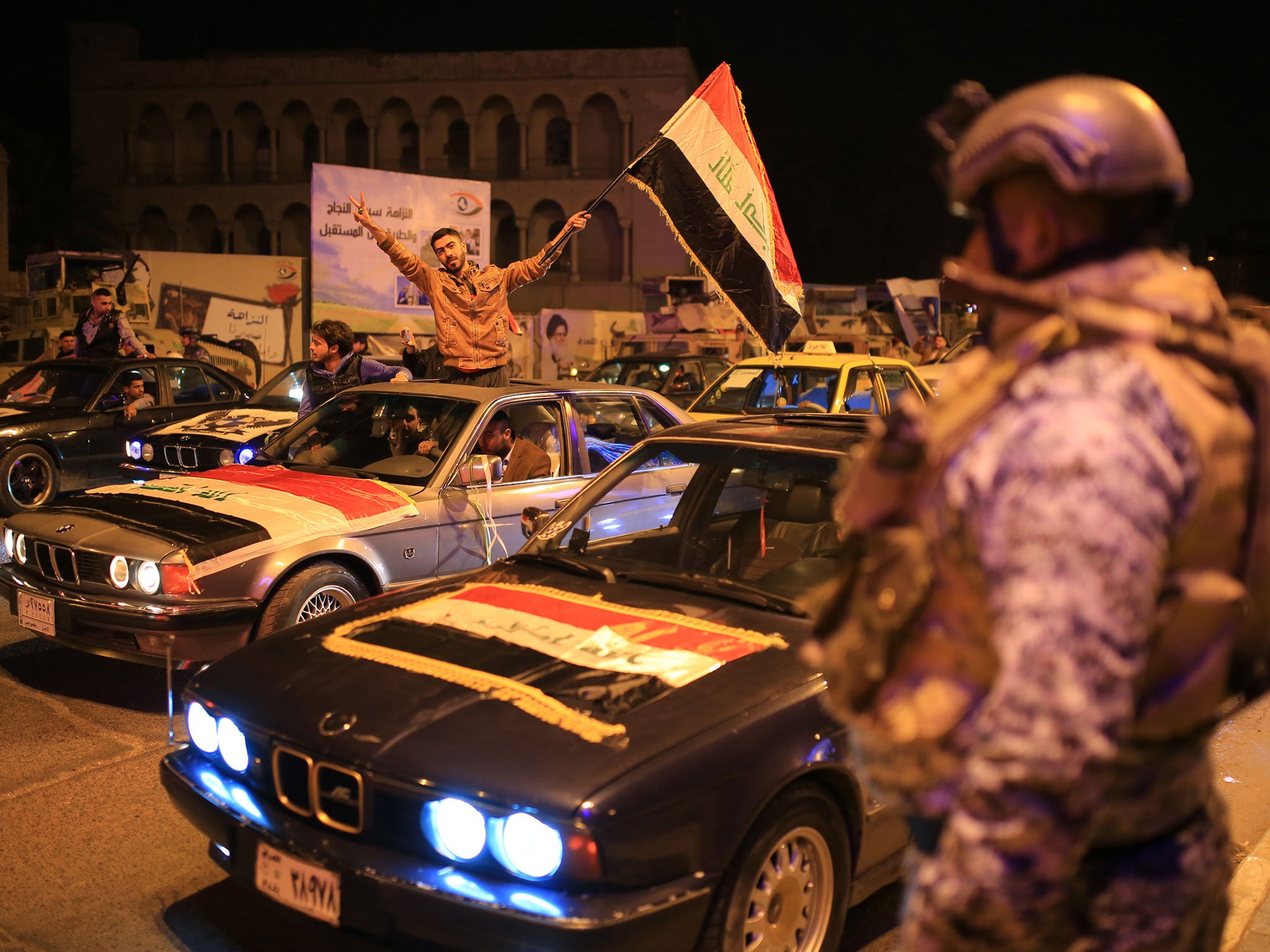 Iraqis celebrate the end of the midnight curfew in the centre of the city