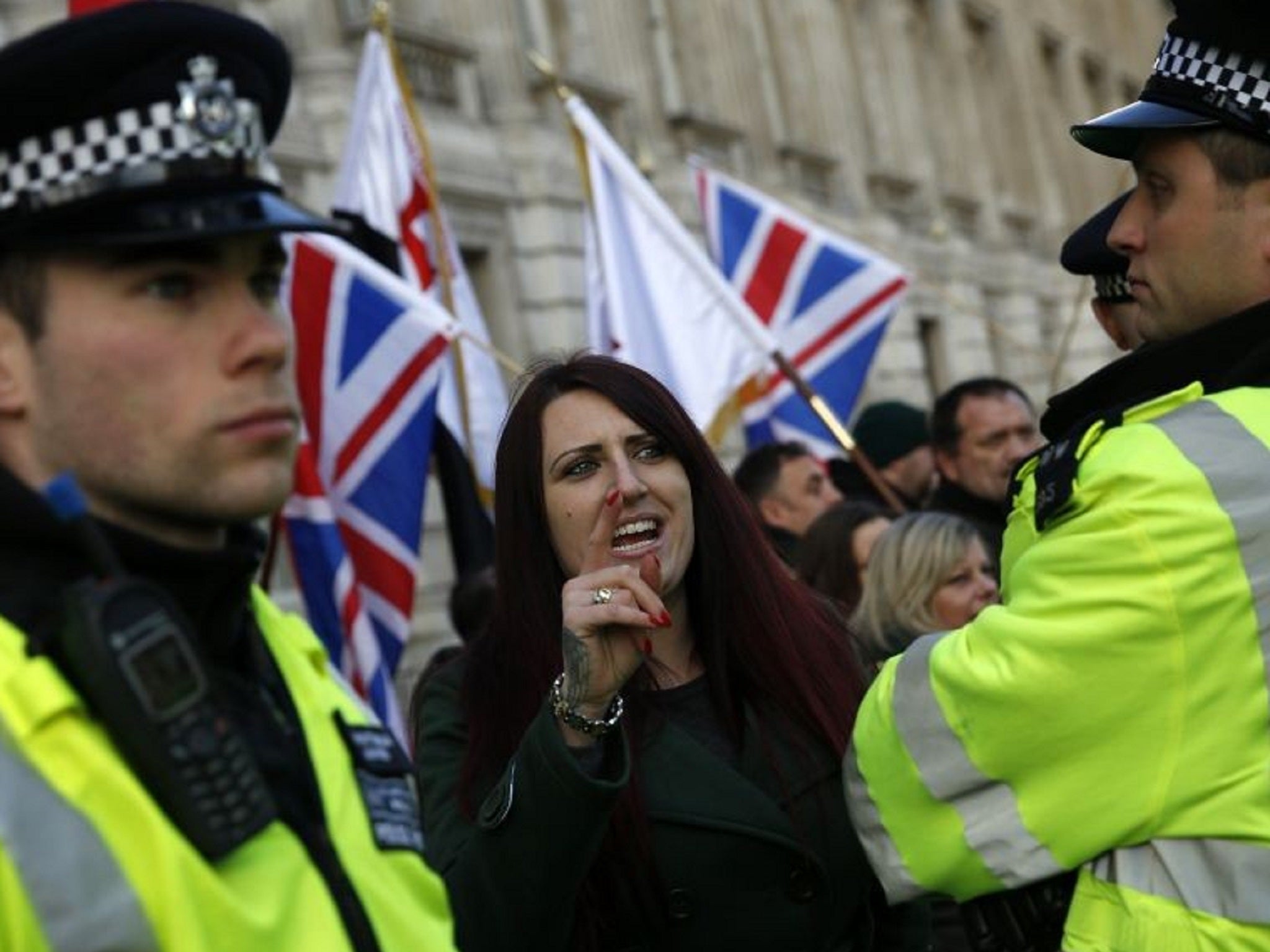 A Britain First member being watched over by police officers
