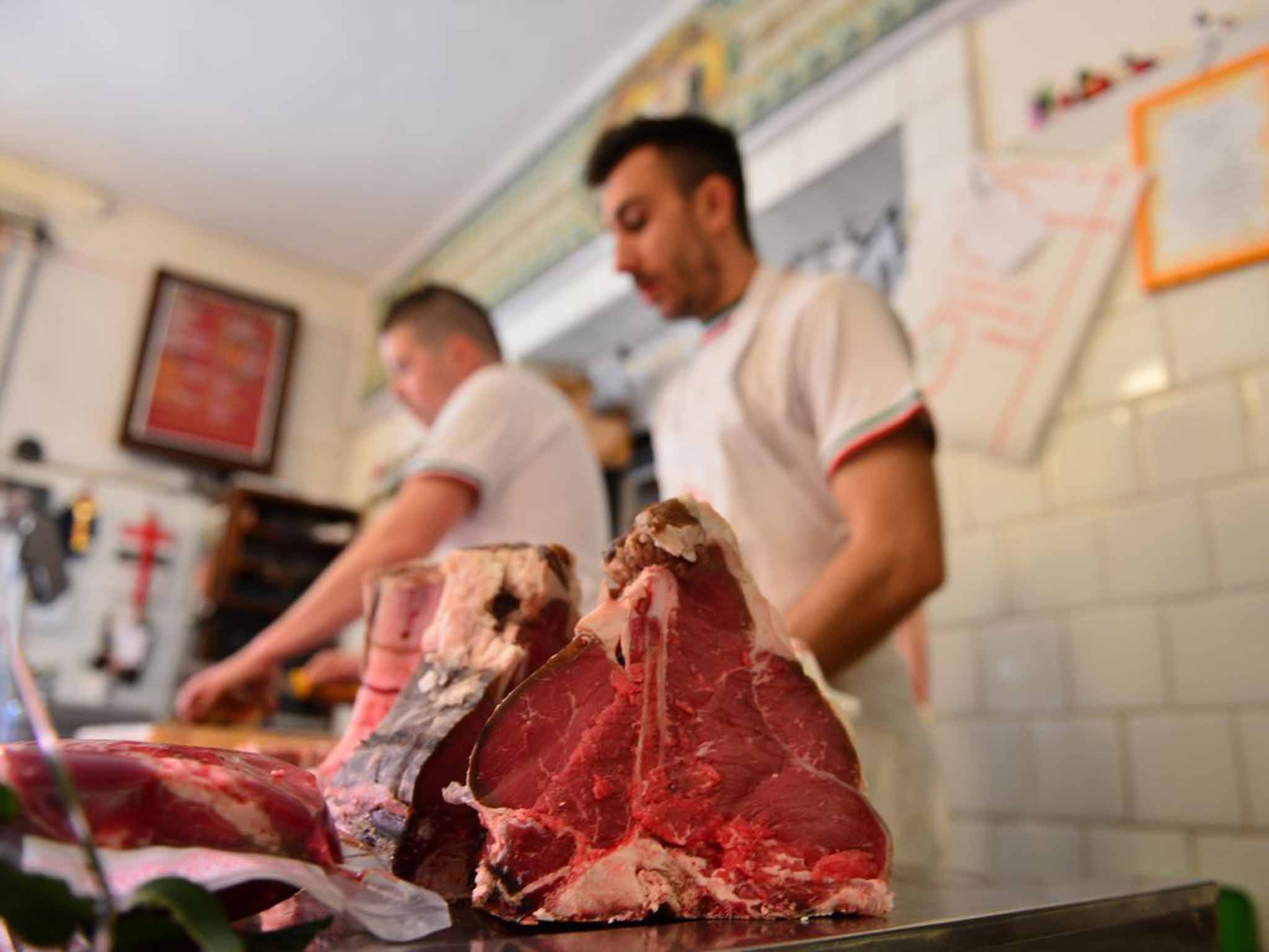 A butcher prepares his cuts at a meat shop in Italy