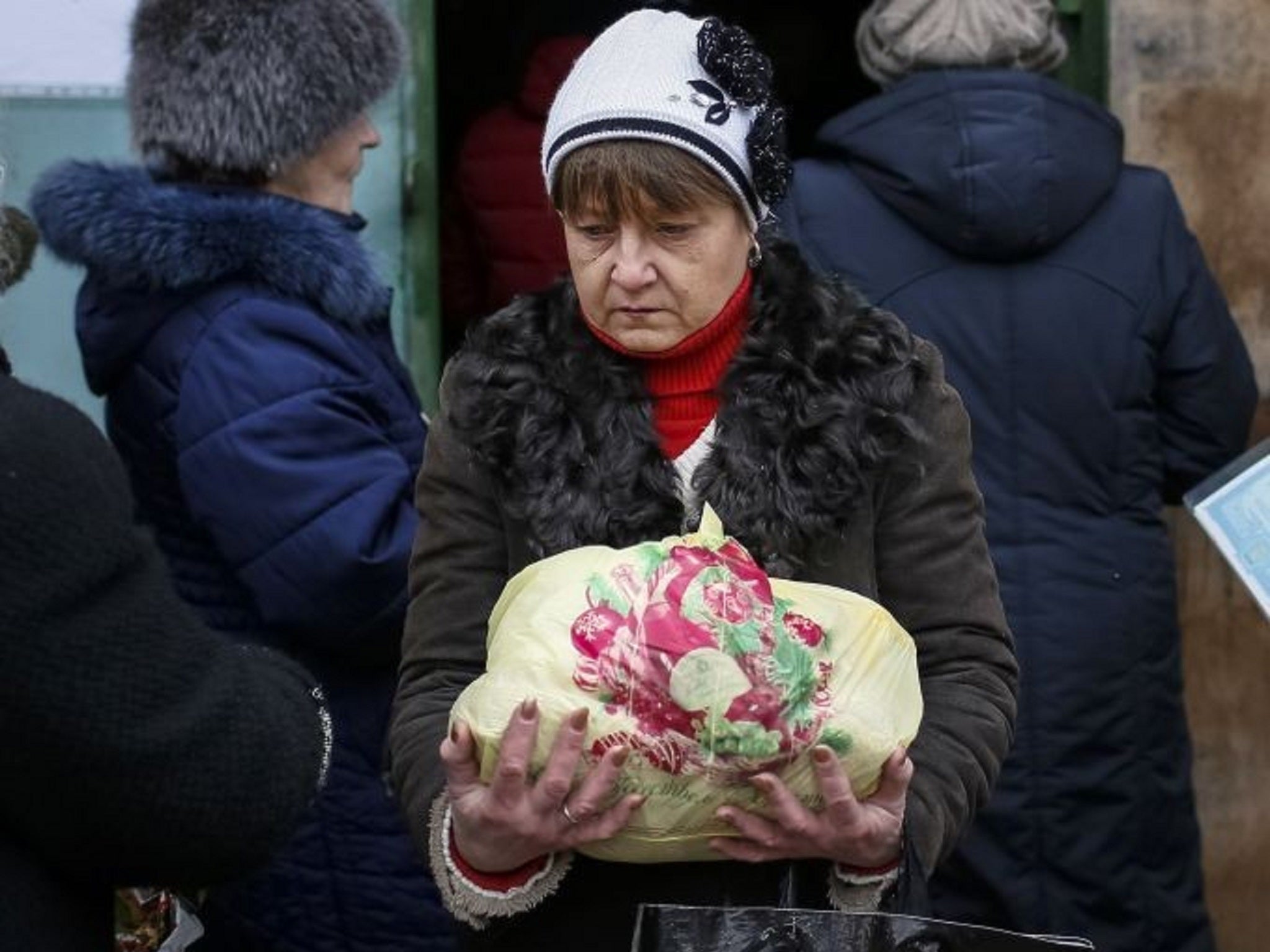 A refugee carries a bag of food donated in aid at a volunteer centre in Slaviansk