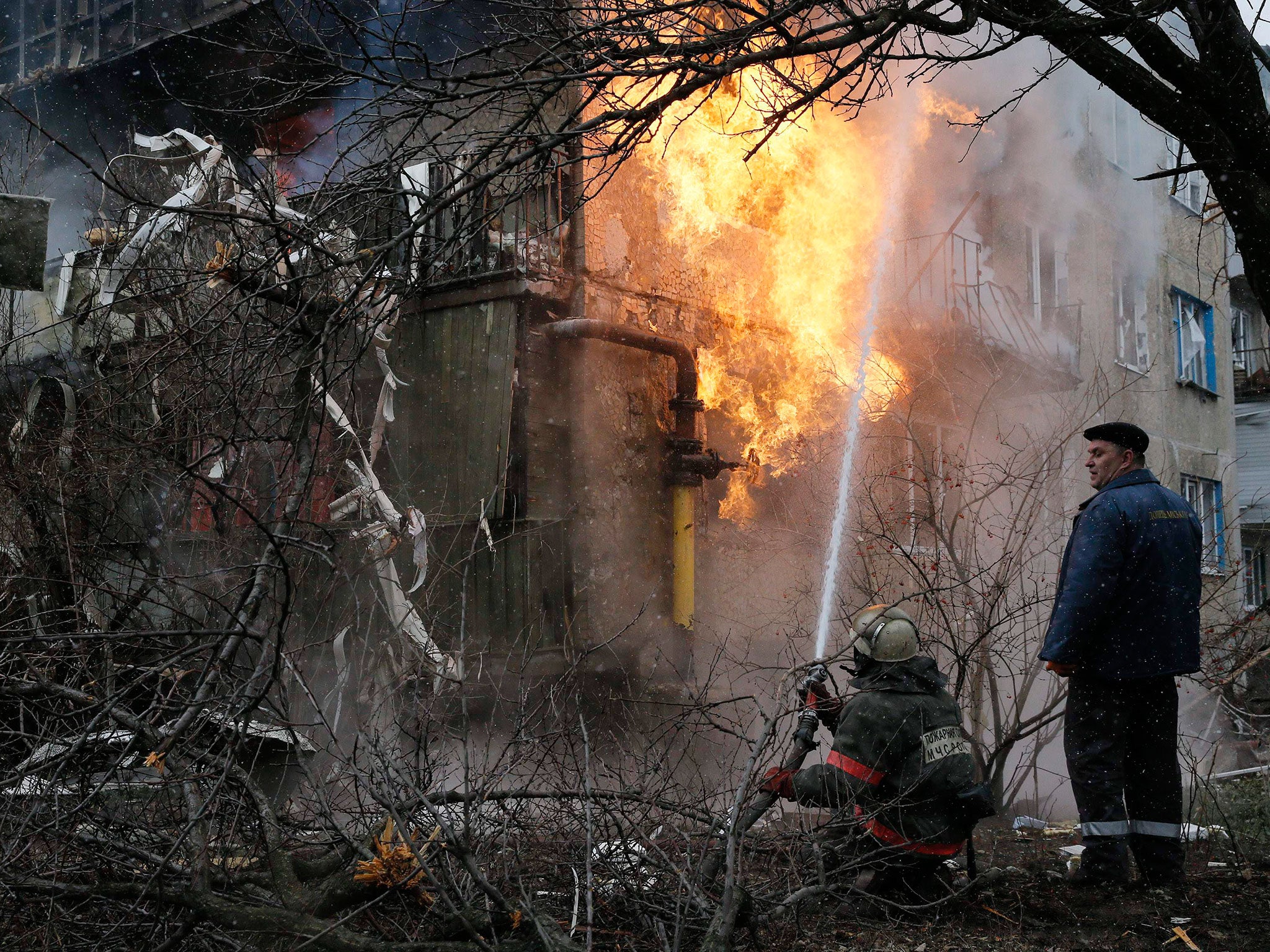 A firefighter works to extinguish a fire at a residential block, which was damaged by a recent shelling near Donetsk