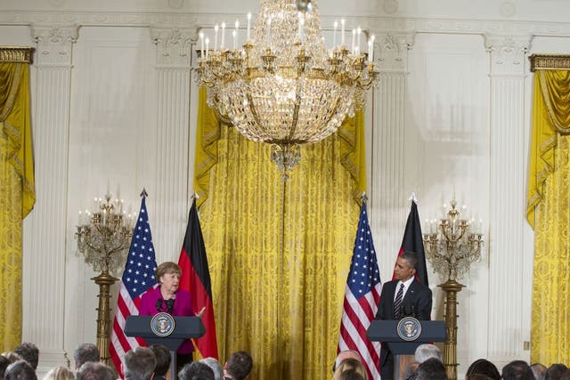 President Barack Obama listen as German Chancellor Angela Merkel speaks during their joint news conference in the East Room of the White House in Washington