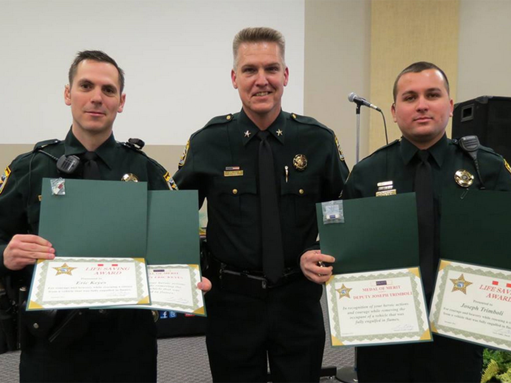 Sheriff Larry Ashley presents Medals of Merit and Lifesaving Awards to Eric Keyes and Joseph Trimboli.