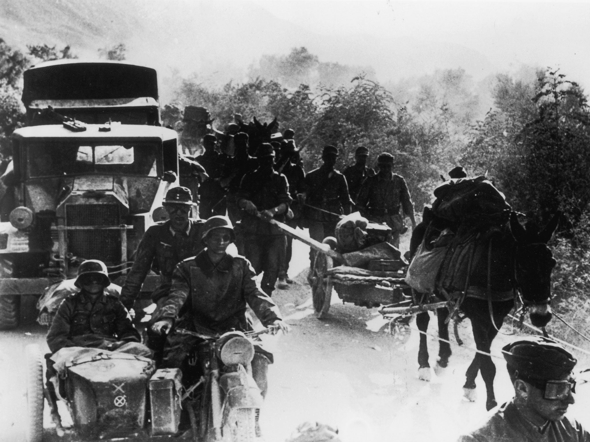 A German military convoy overtakes a group of Greek peasants on a rural track during the early stages of the German occupation of Greece in 1941