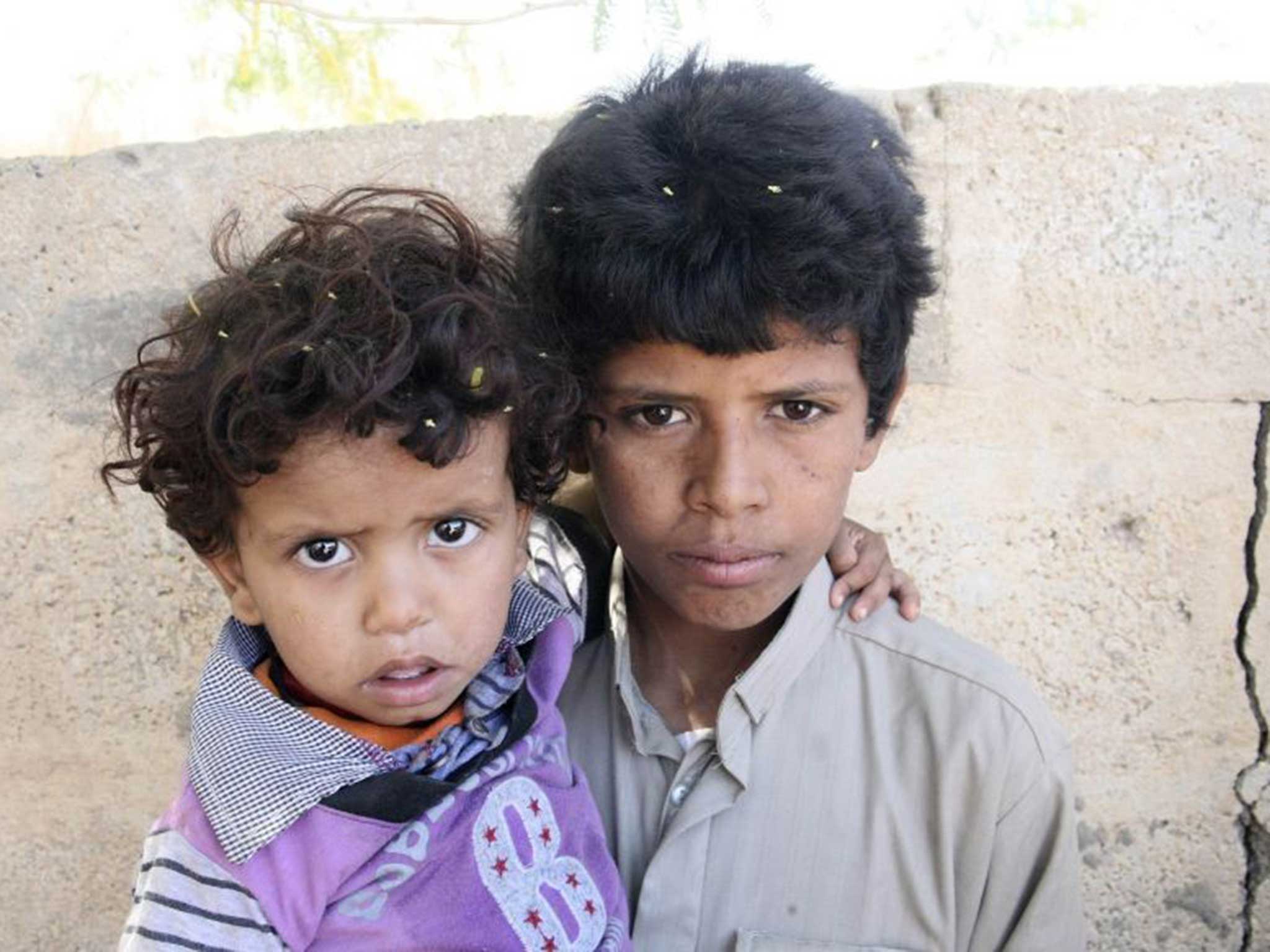 Mohammed Saleh Taeiman (R) poses for a photo with his younger brother outside their family's house in Marib province in 2013