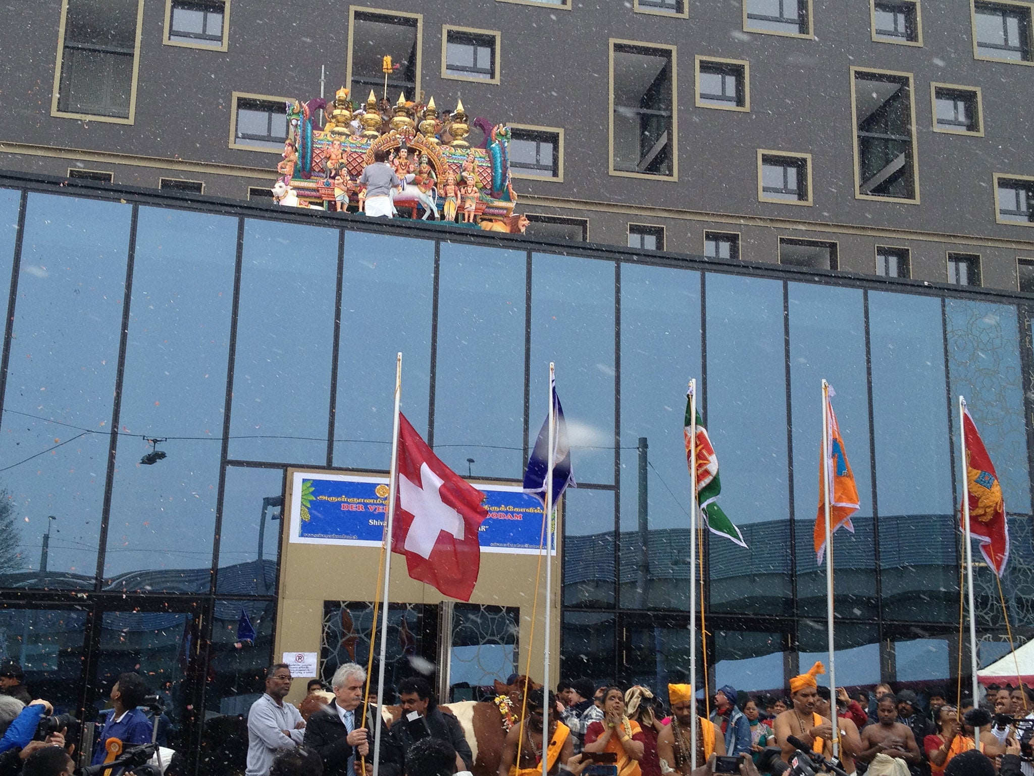 The Swiss flag being raised at the opening of the Haus der Religionen, in Bern