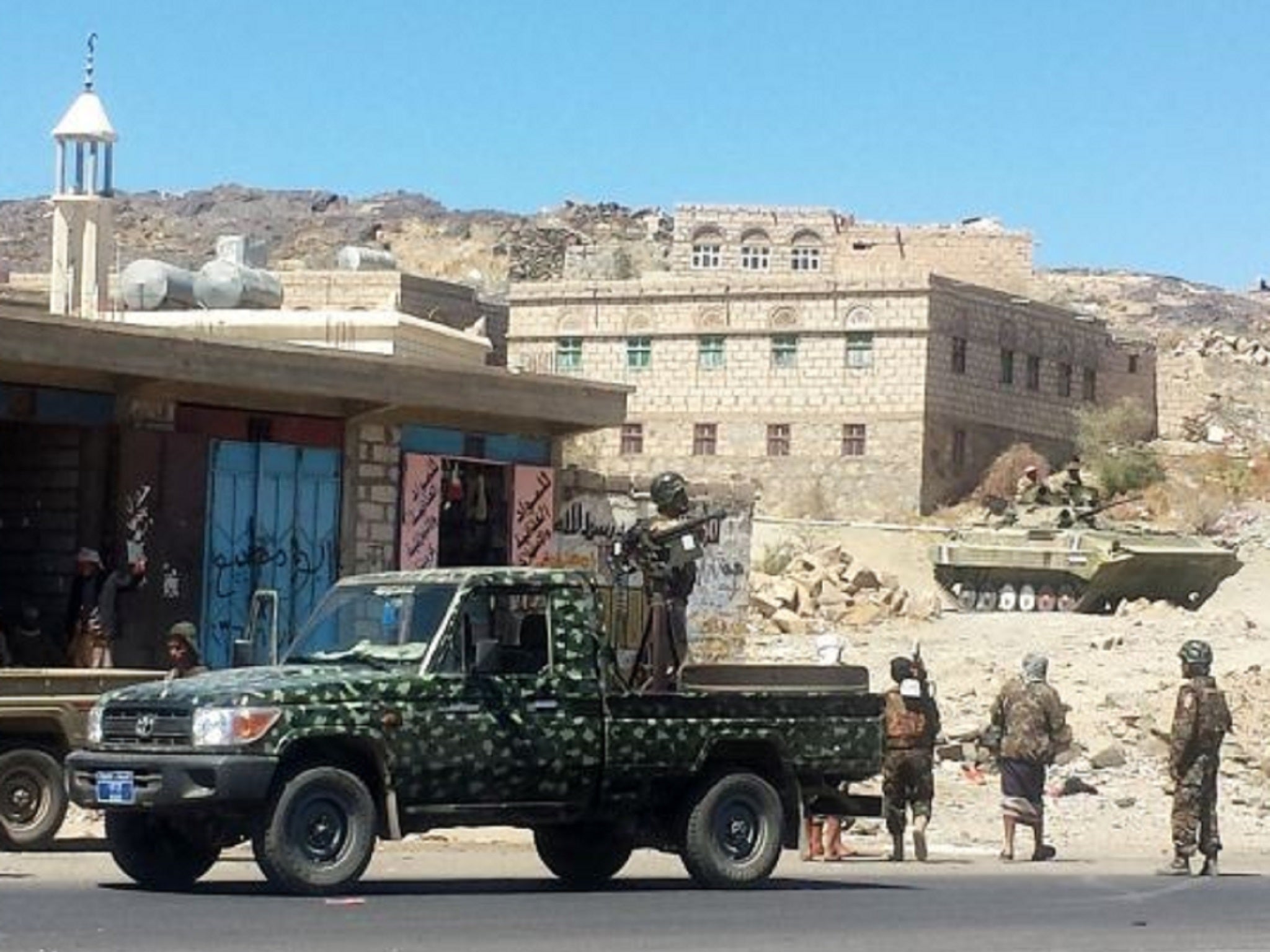 Shia Houthi fighters stand near armed vehicles in the Al-Bayda province, south of Yemeni capital Sanaa