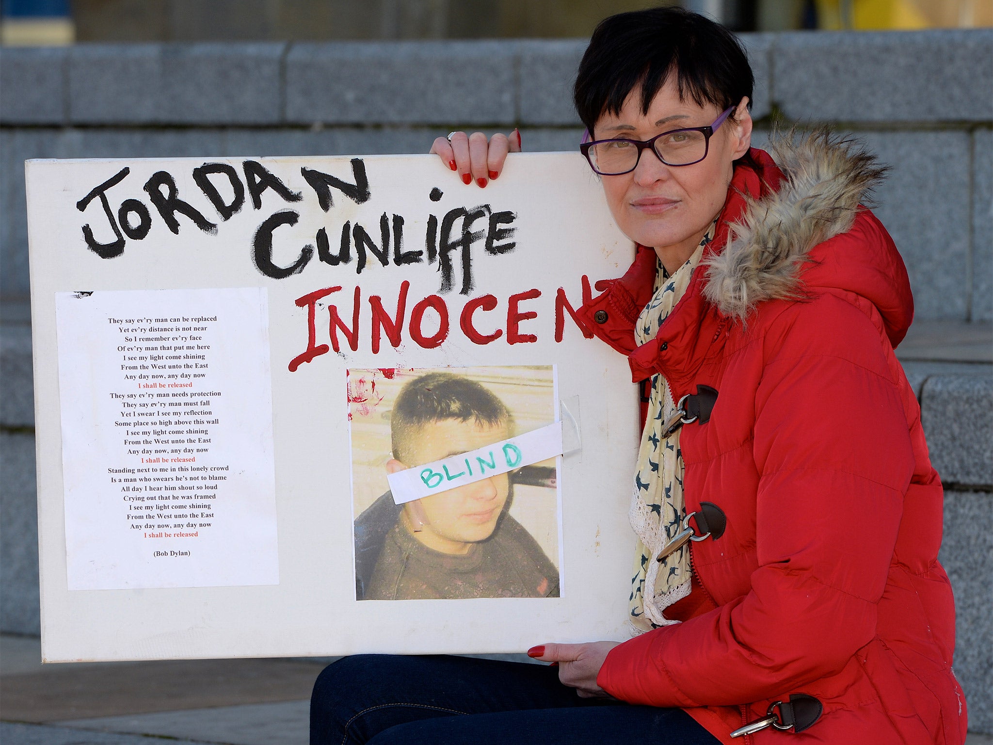 Janet Cunliffe holds a picture of Jordan during a protest in Liverpool