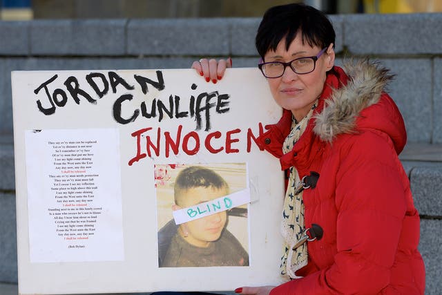 Janet Cunliffe holds a picture of Jordan during a protest in Liverpool