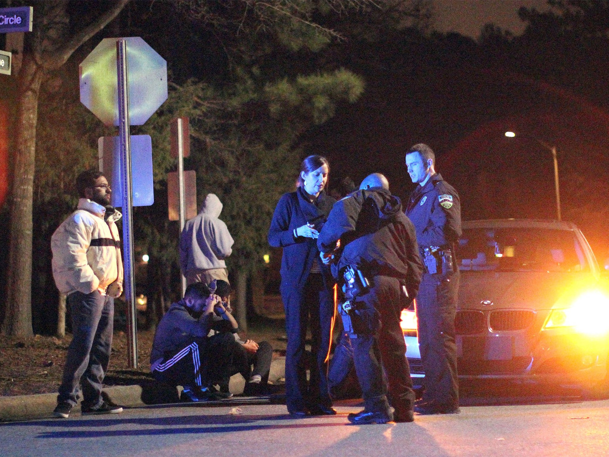 Chapel Hill police officers investigate the scene of the three murders