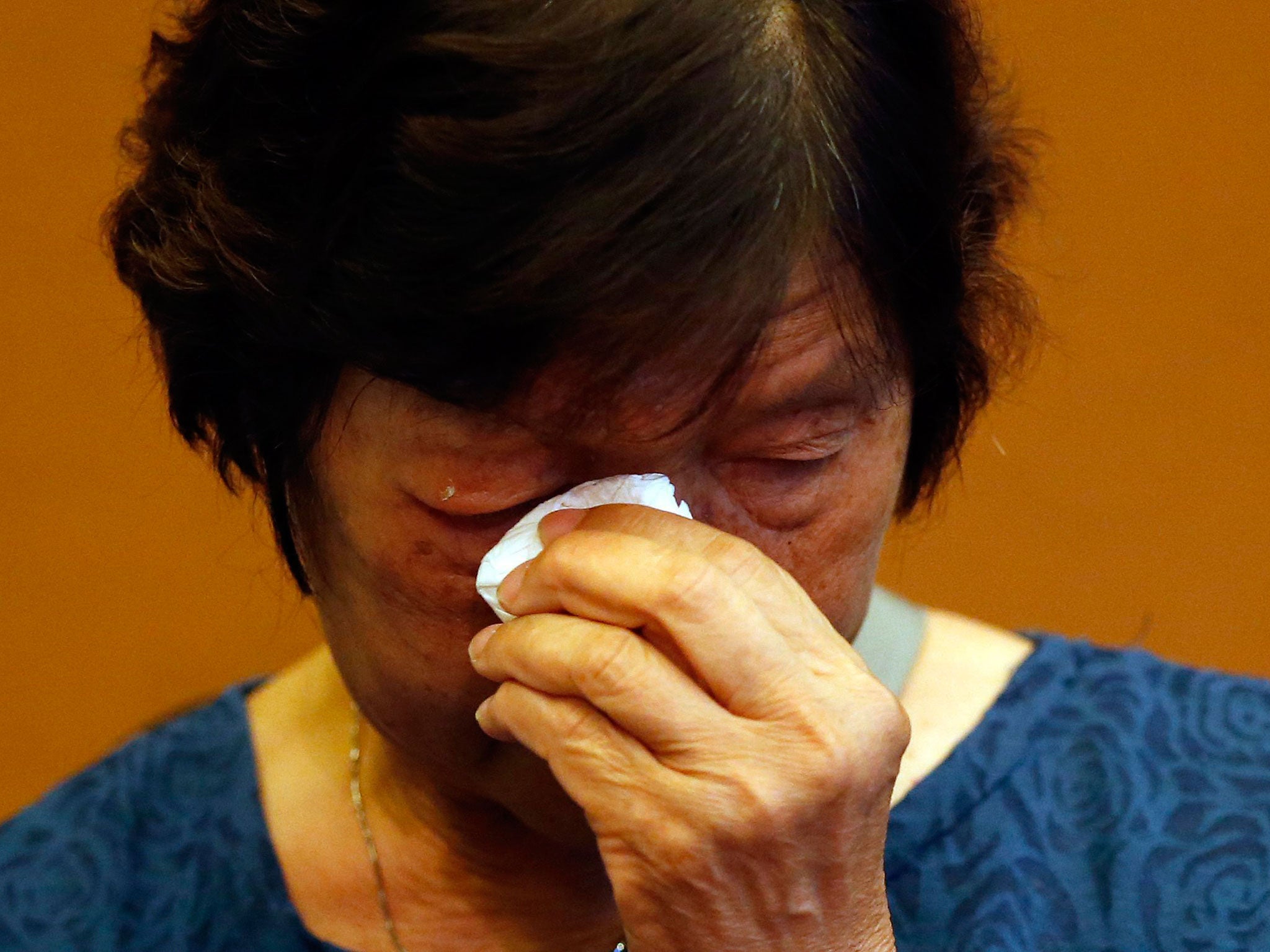 Halen Chan, the mother of death-row prisoner Andrew Chan, wipes away tears during a press conference in Jakarta