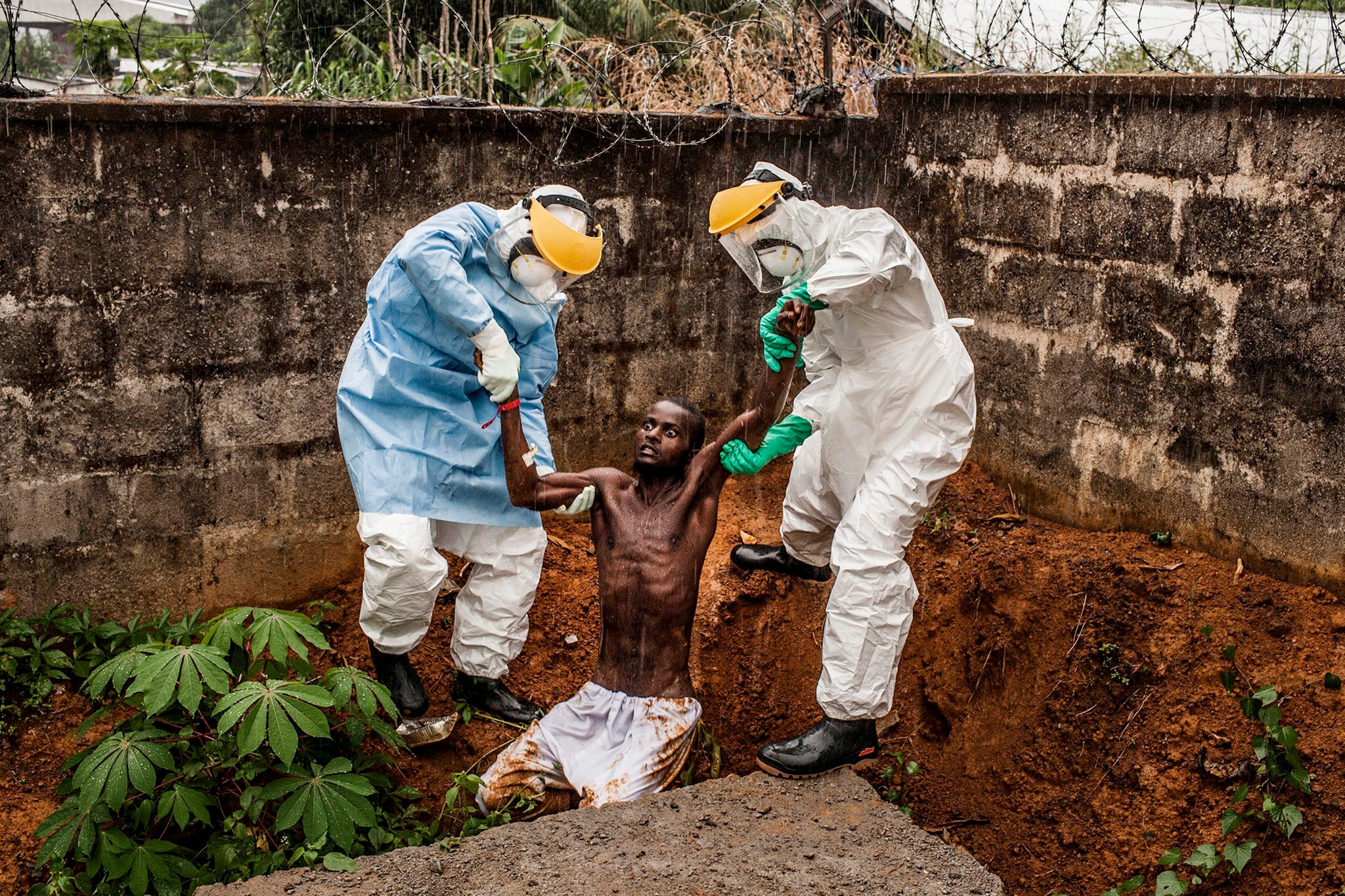 General News winner: Petter Muller's photograph of a delirious Ebola patient being lifted back to his isolation unit in Sierra Leone