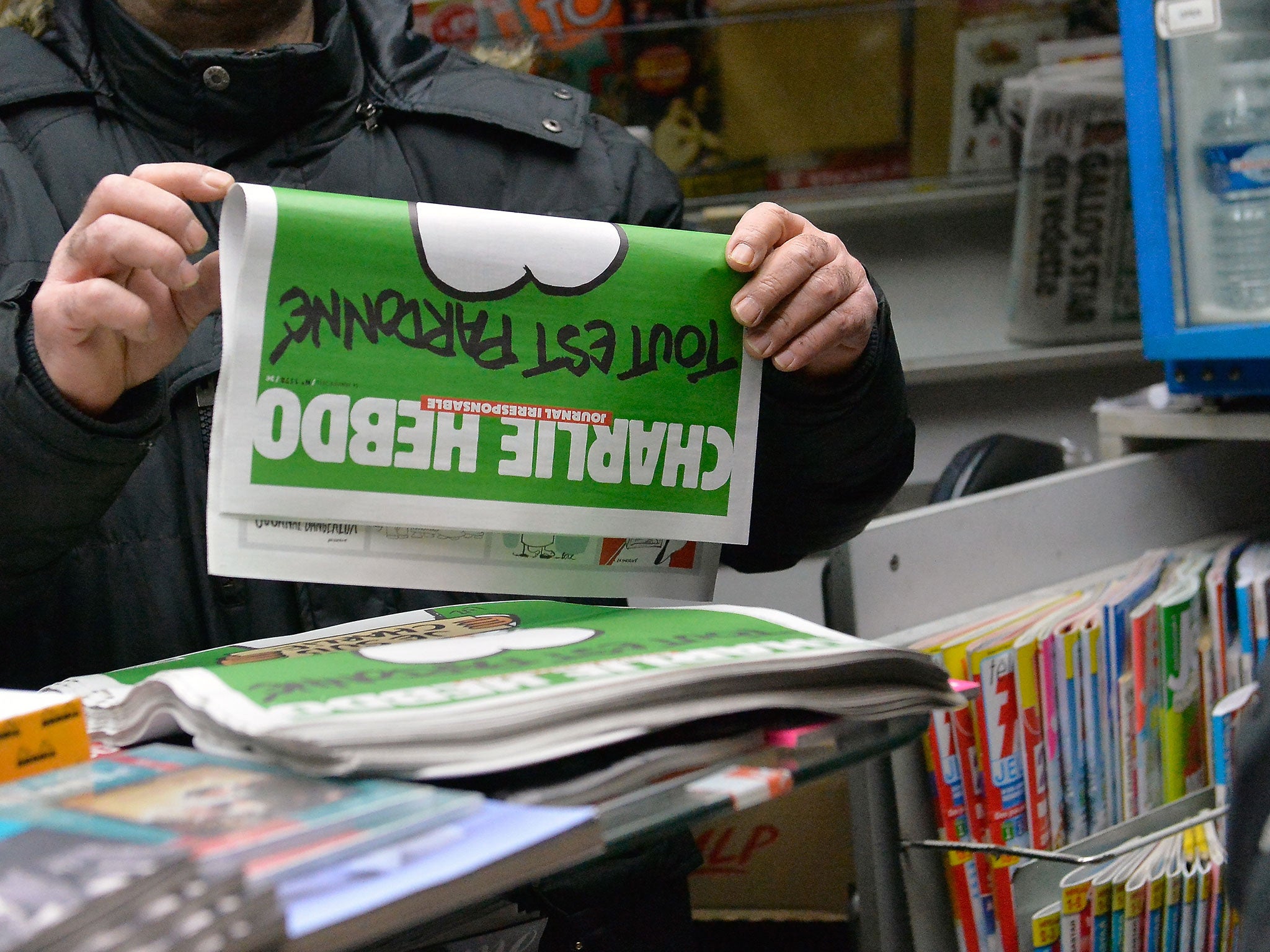 A man buys a copy of the new edition of Charlie Hebdo magazine